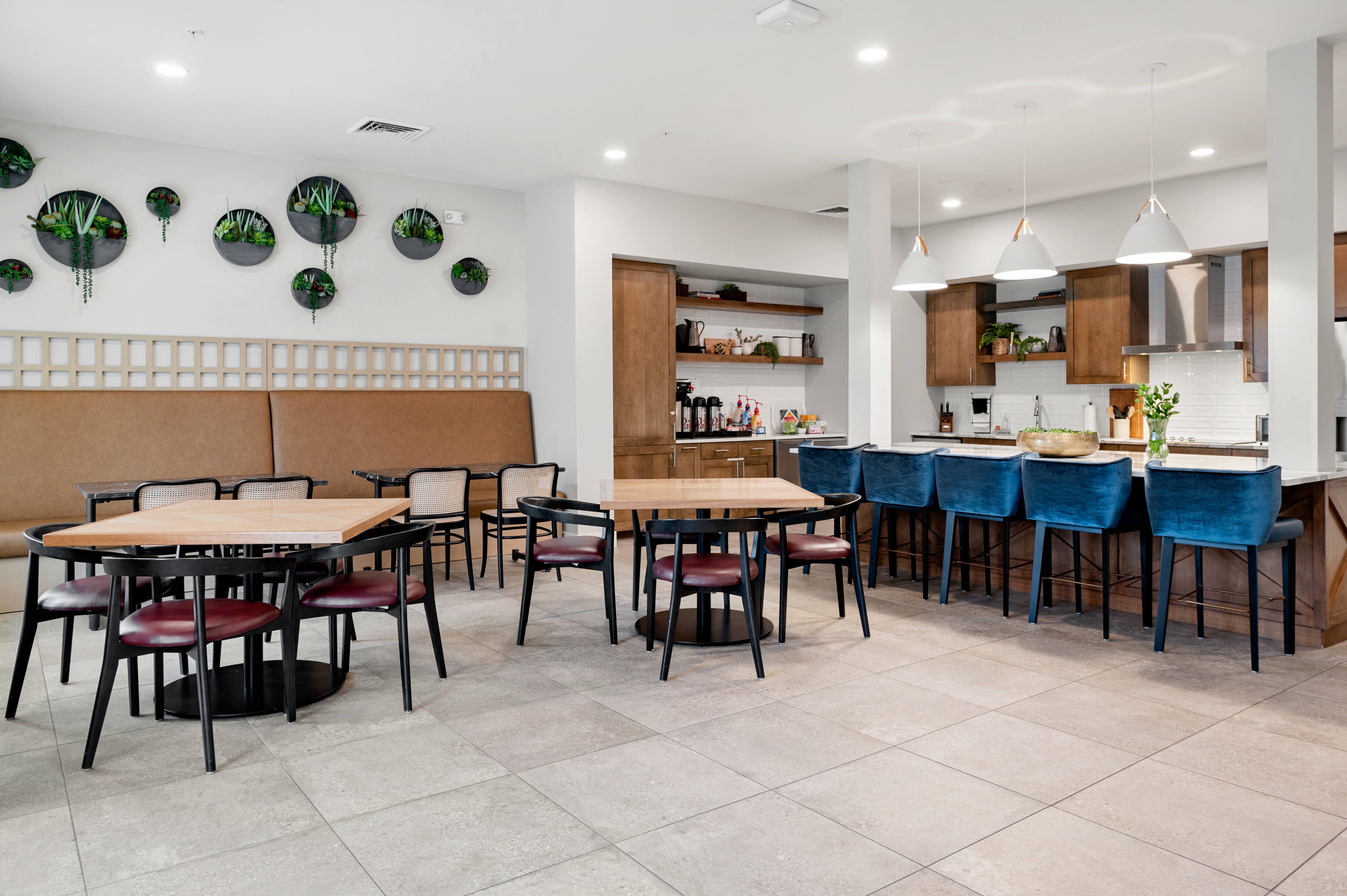 the dining area of a restaurant with tables and chairs and a kitchen