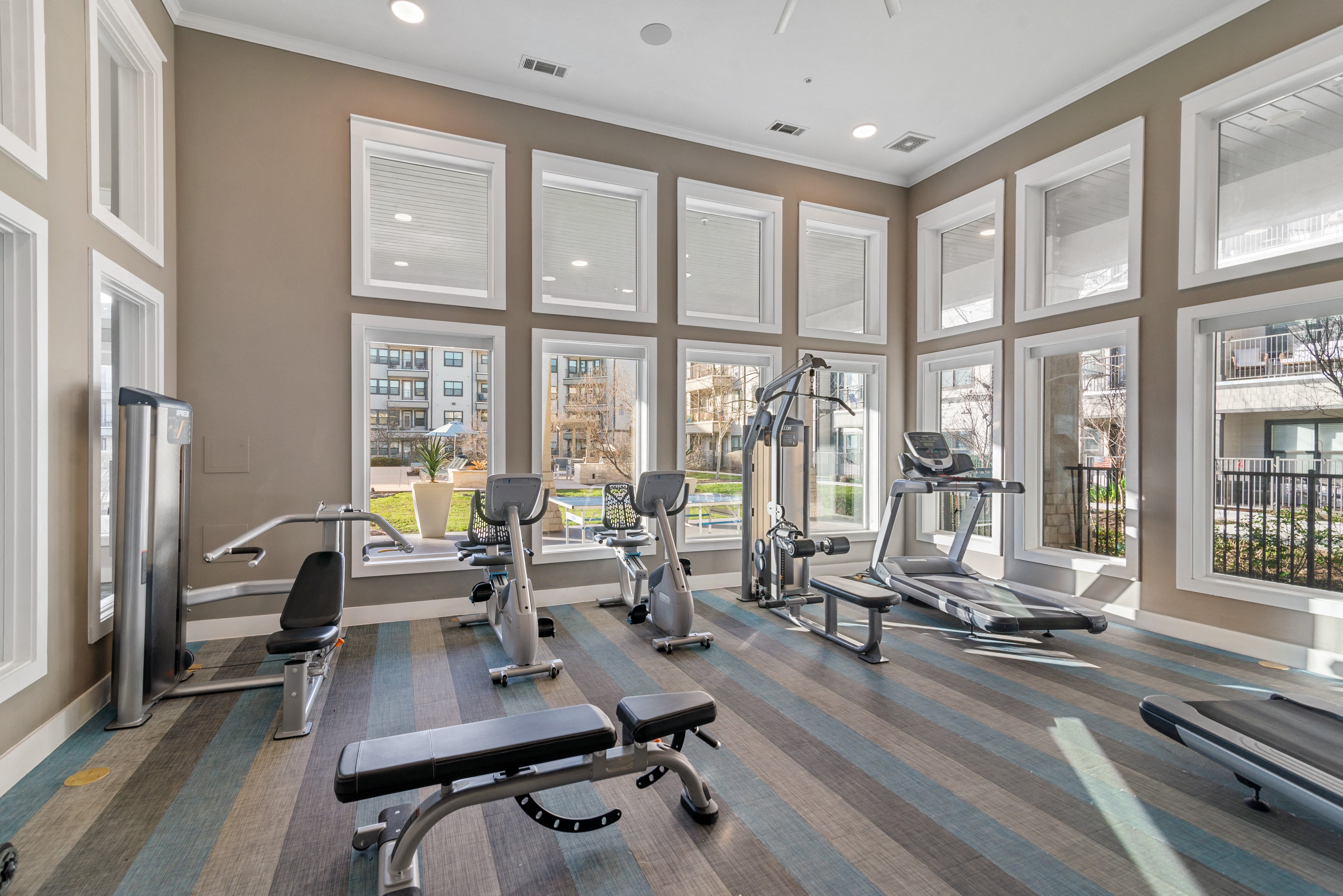 a gym with fitness machines and equipment at a senior apartment community