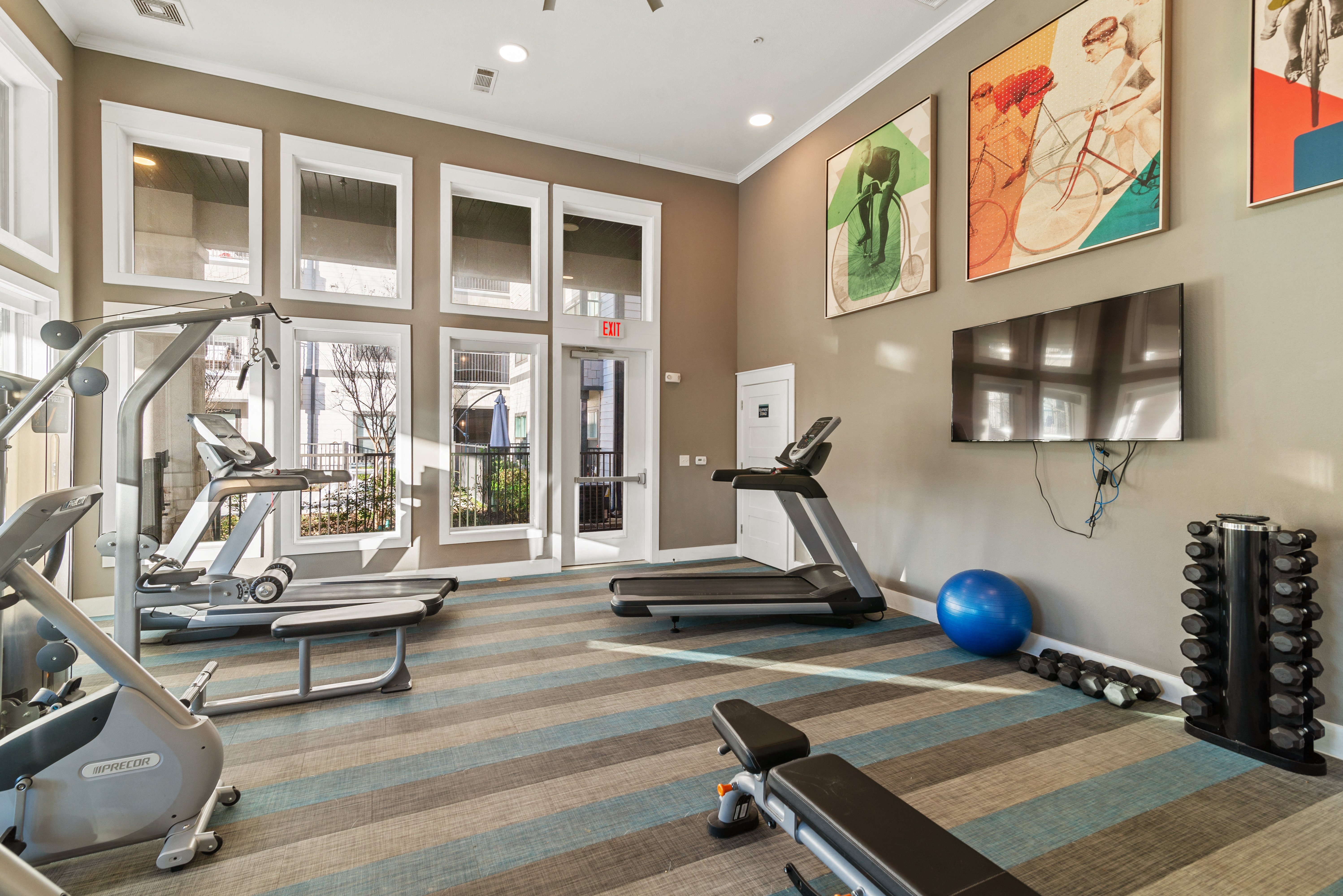 a gym with fitness machines and equipment at a senior apartment community