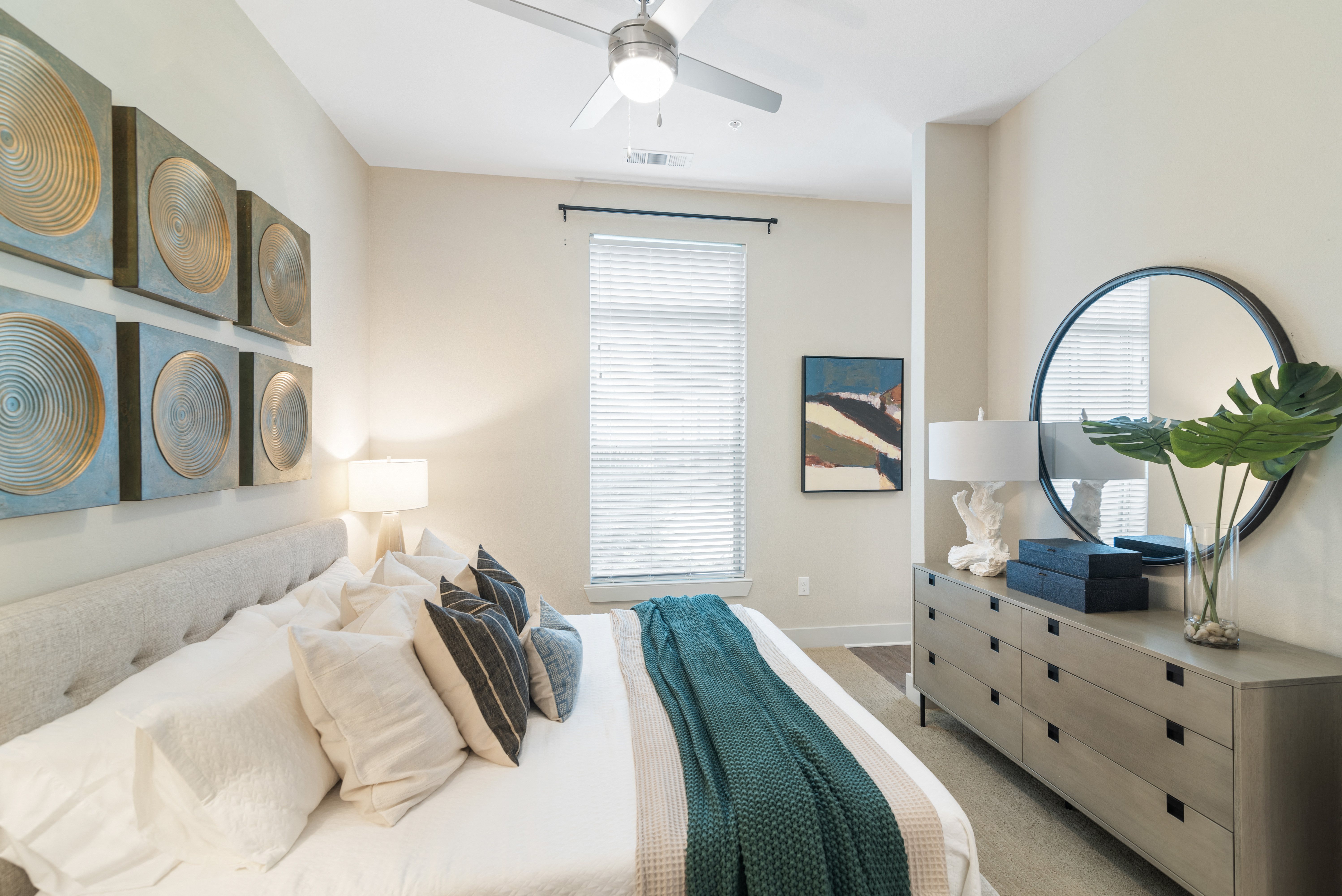 a king size bed in a bedroom with a ceiling fan at a senior apartment community