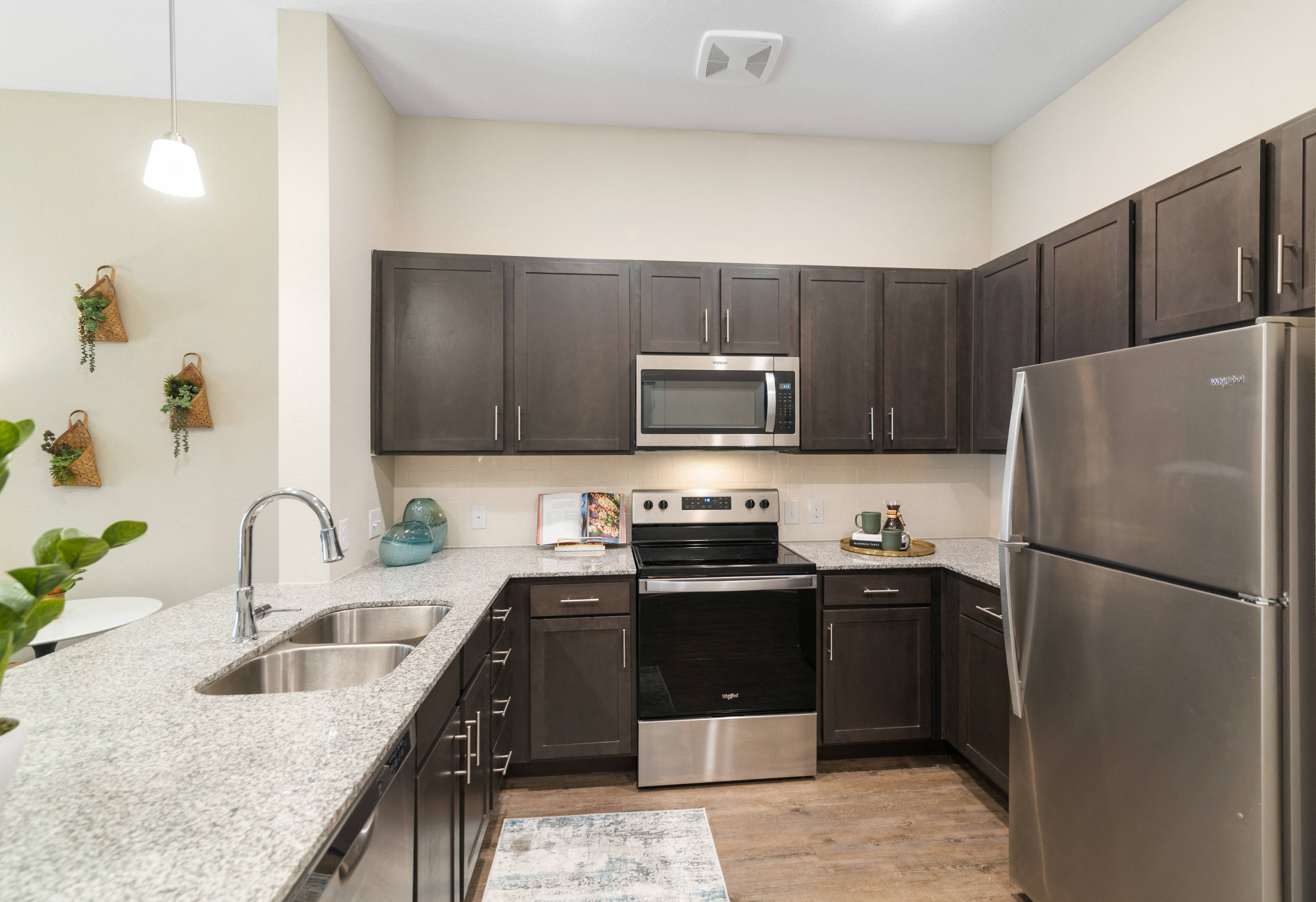 a kitchen with granite counter tops and stainless steel appliances at a senior apartment community
