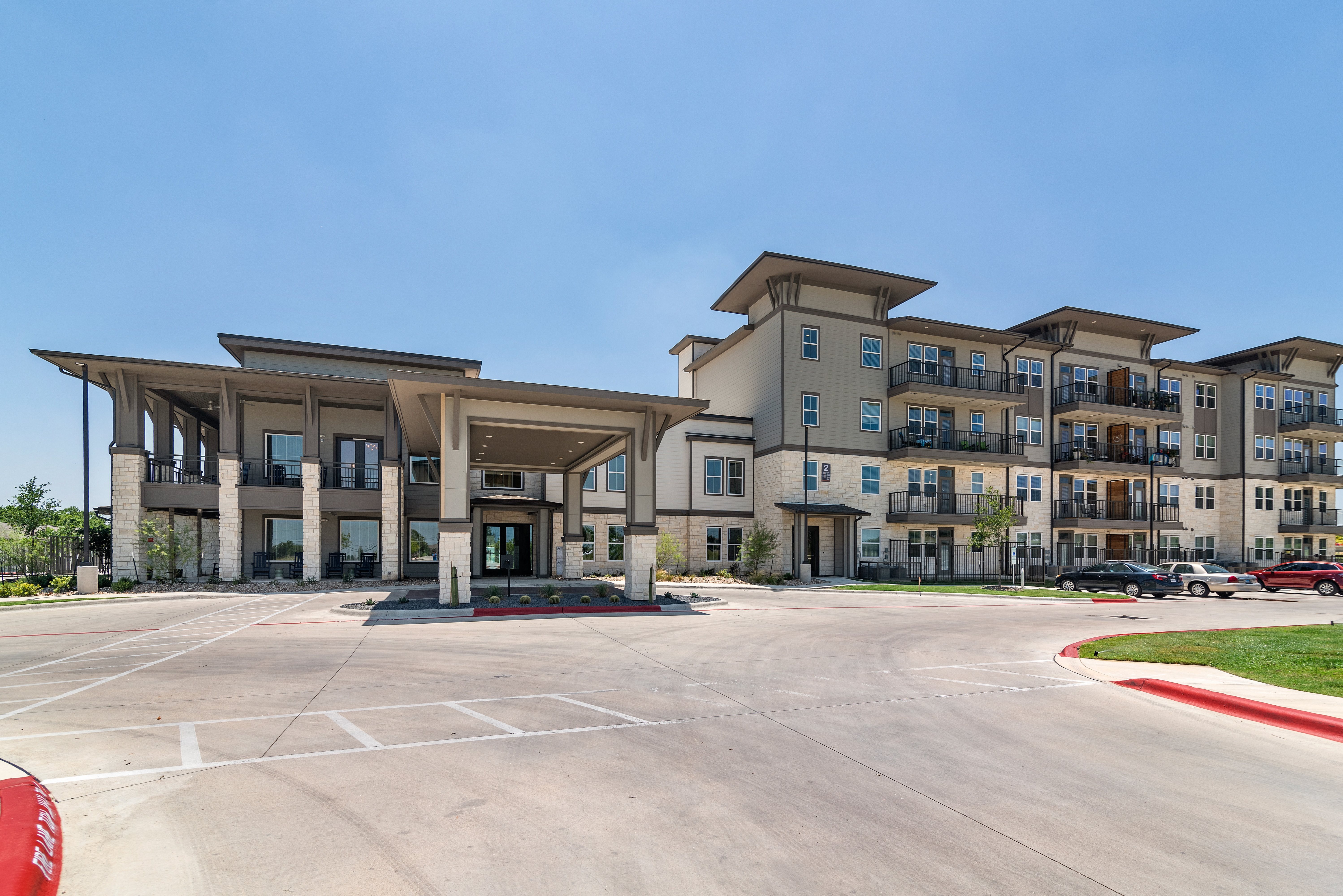 an empty parking lot in front of an apartment building