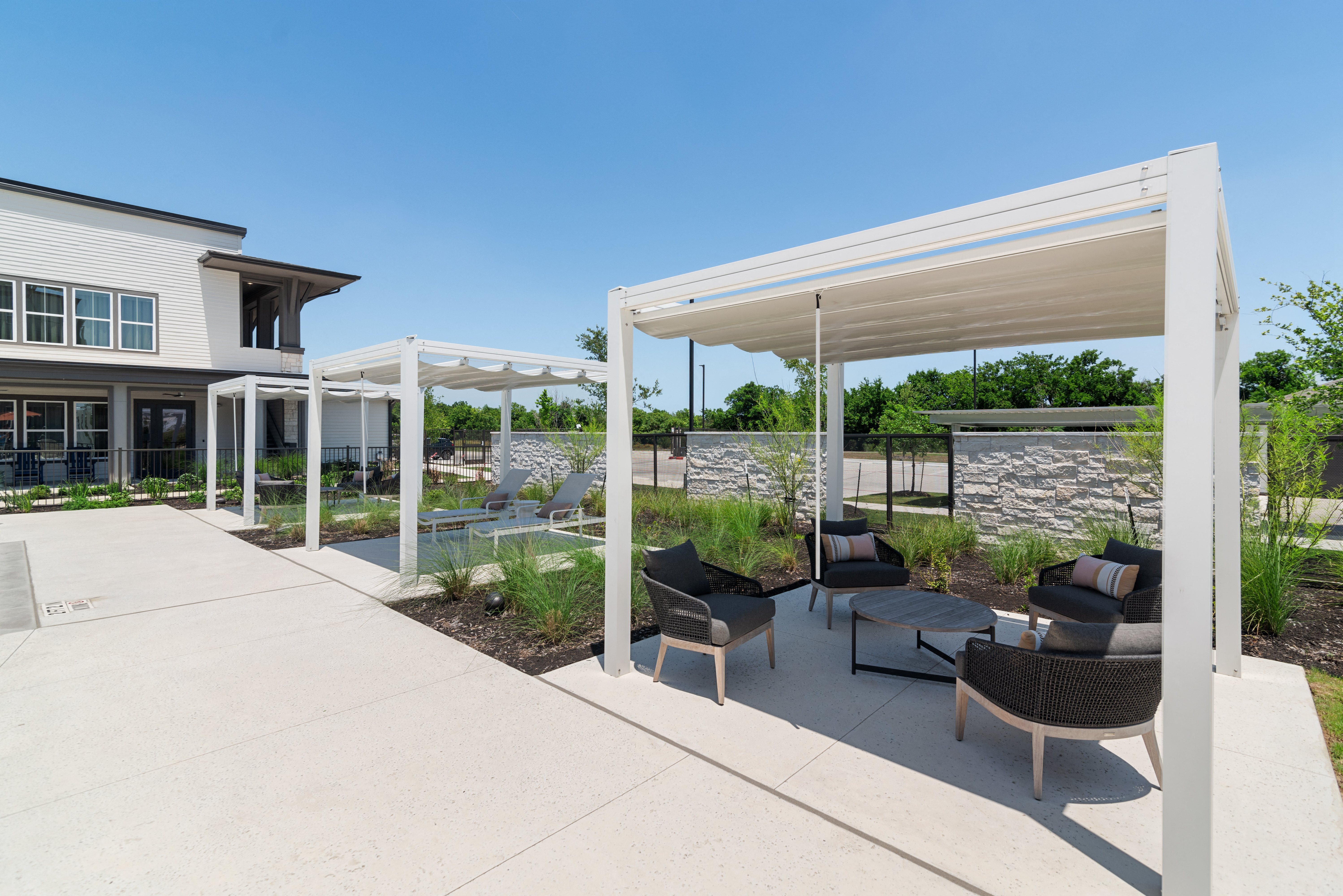 a covered patio with chairs and tables under a white canopy