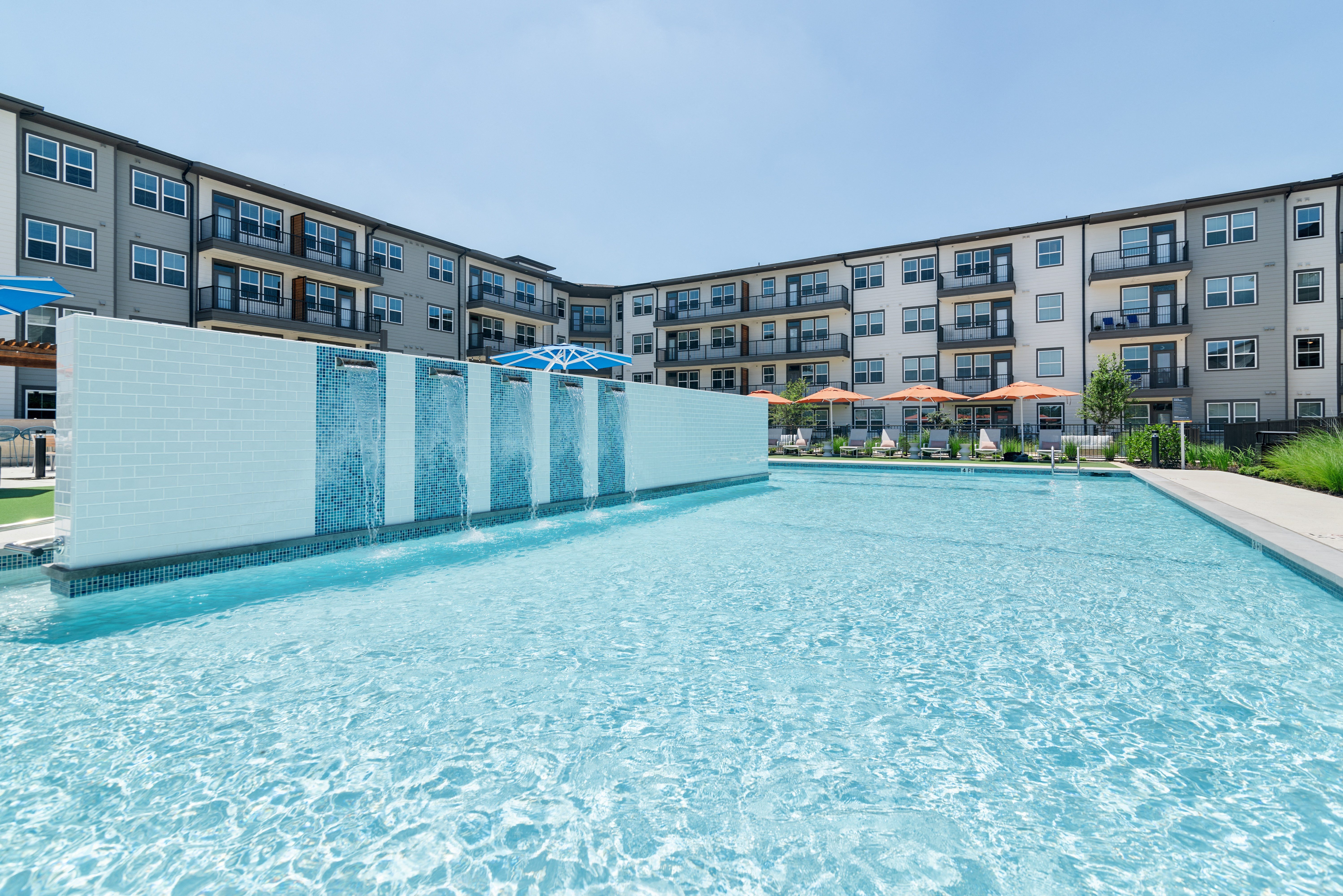 a large swimming pool with an apartment building in the background
