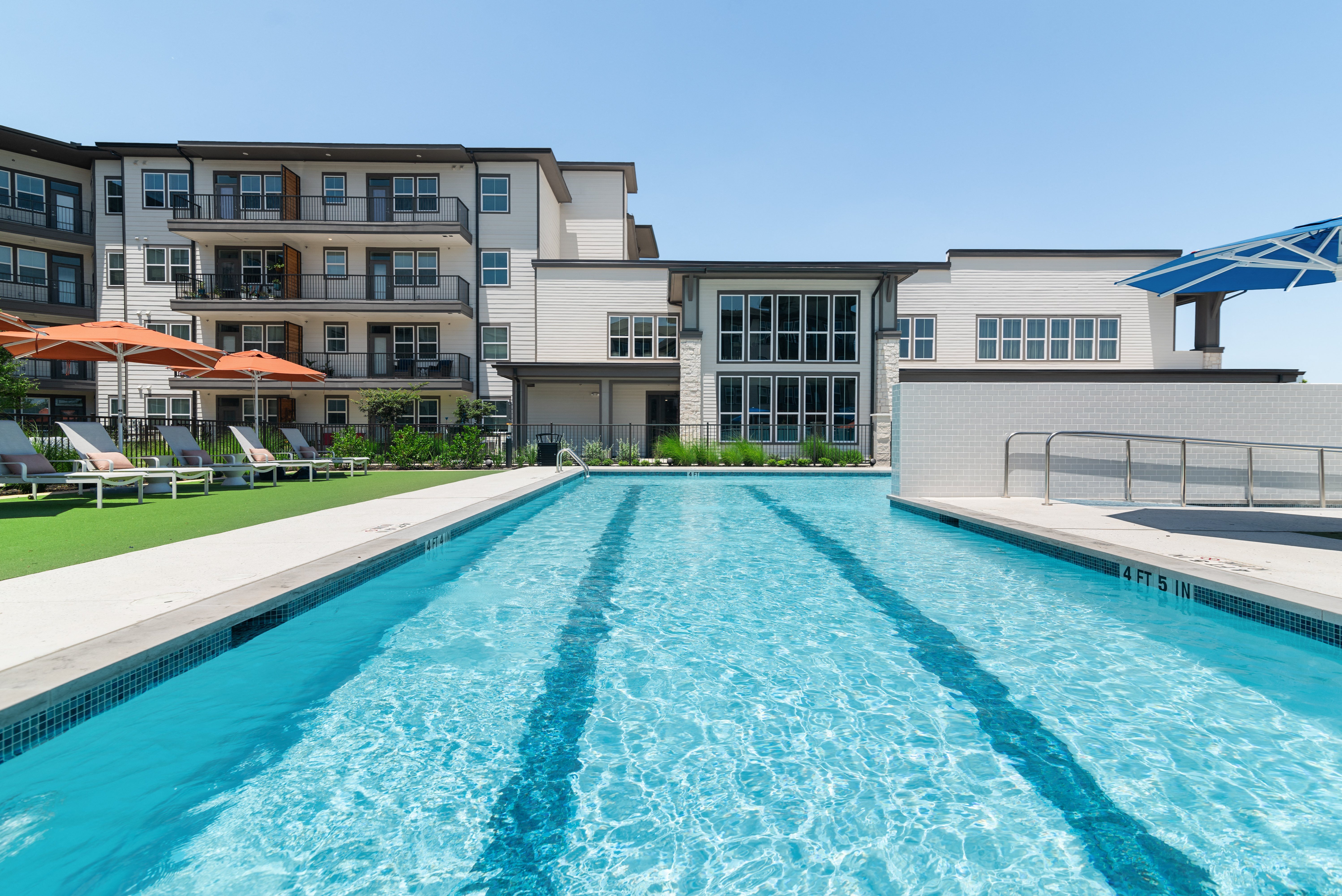 a swimming pool with an apartment building in the background