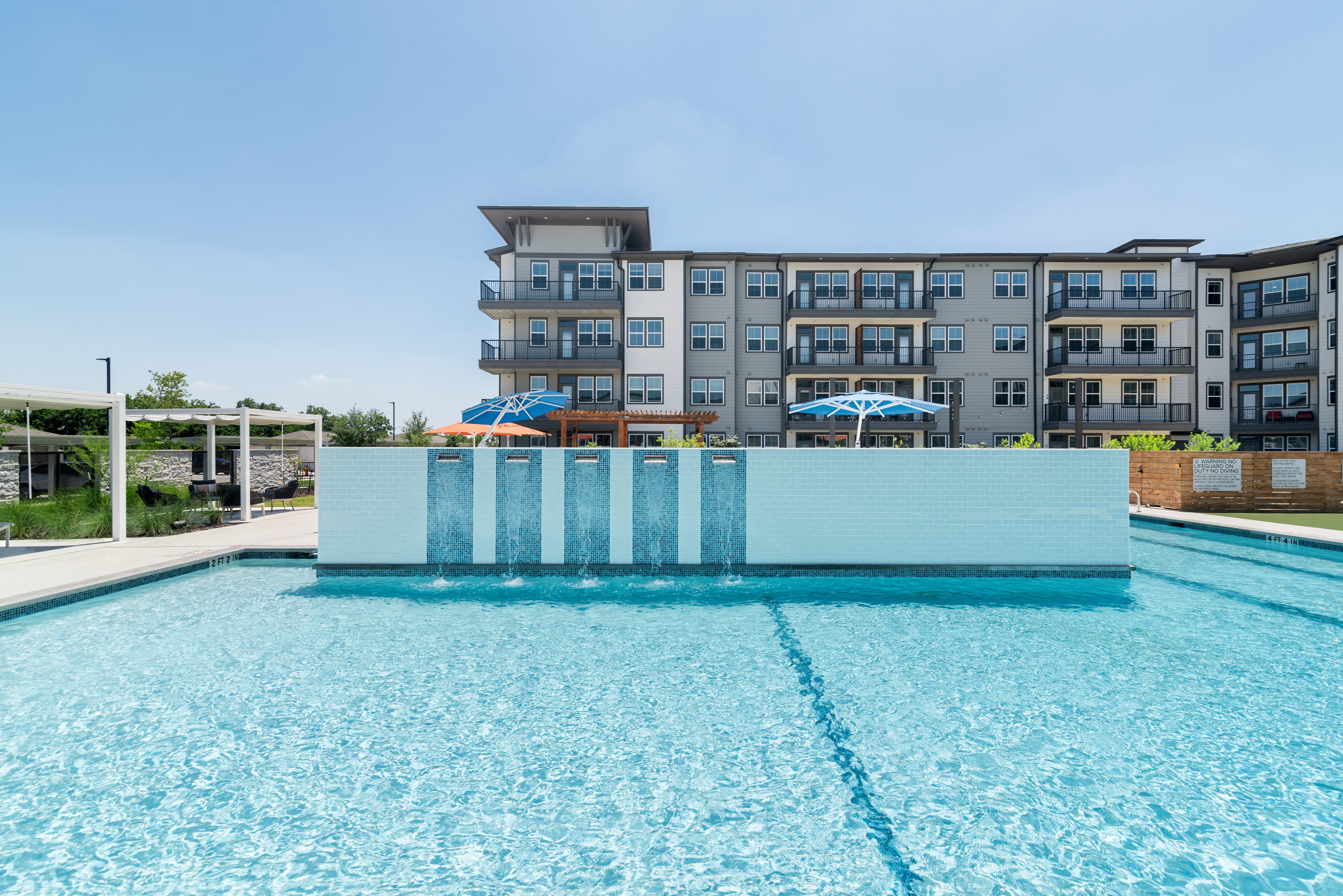 a large pool with an apartment building in the background