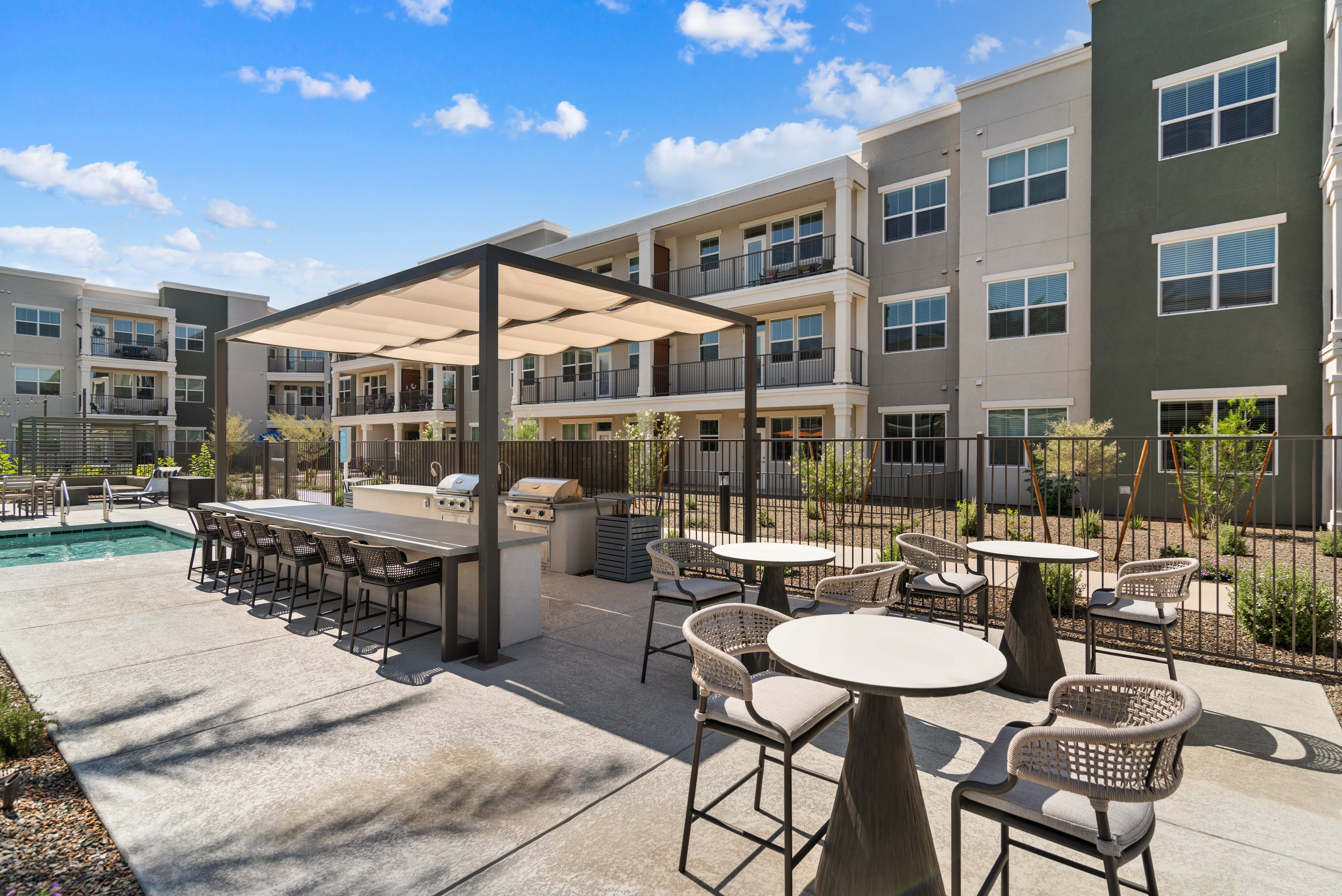 A patio with a table and chairs is surrounded by apartment buildings.