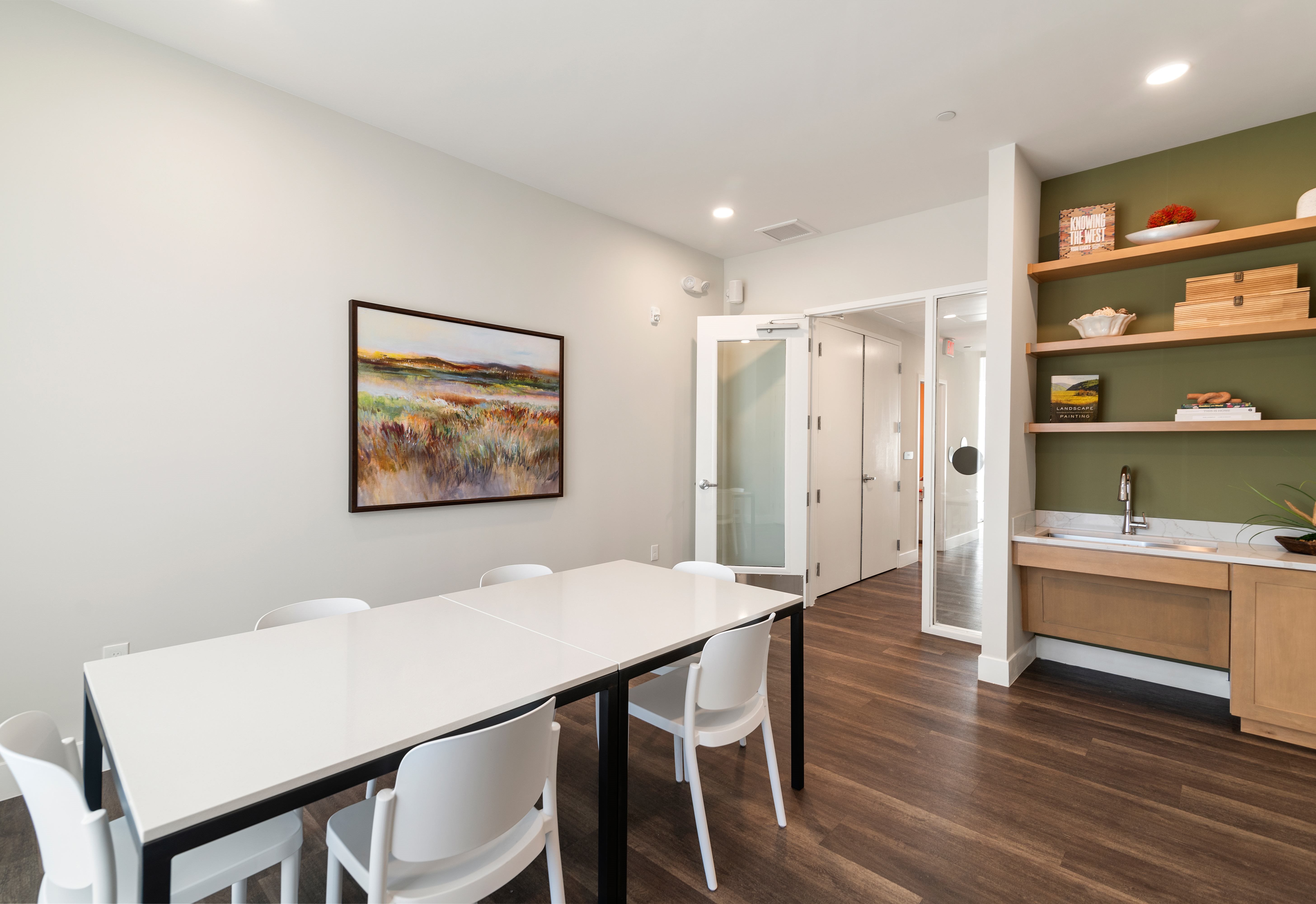 A dining room with a white table and chairs.