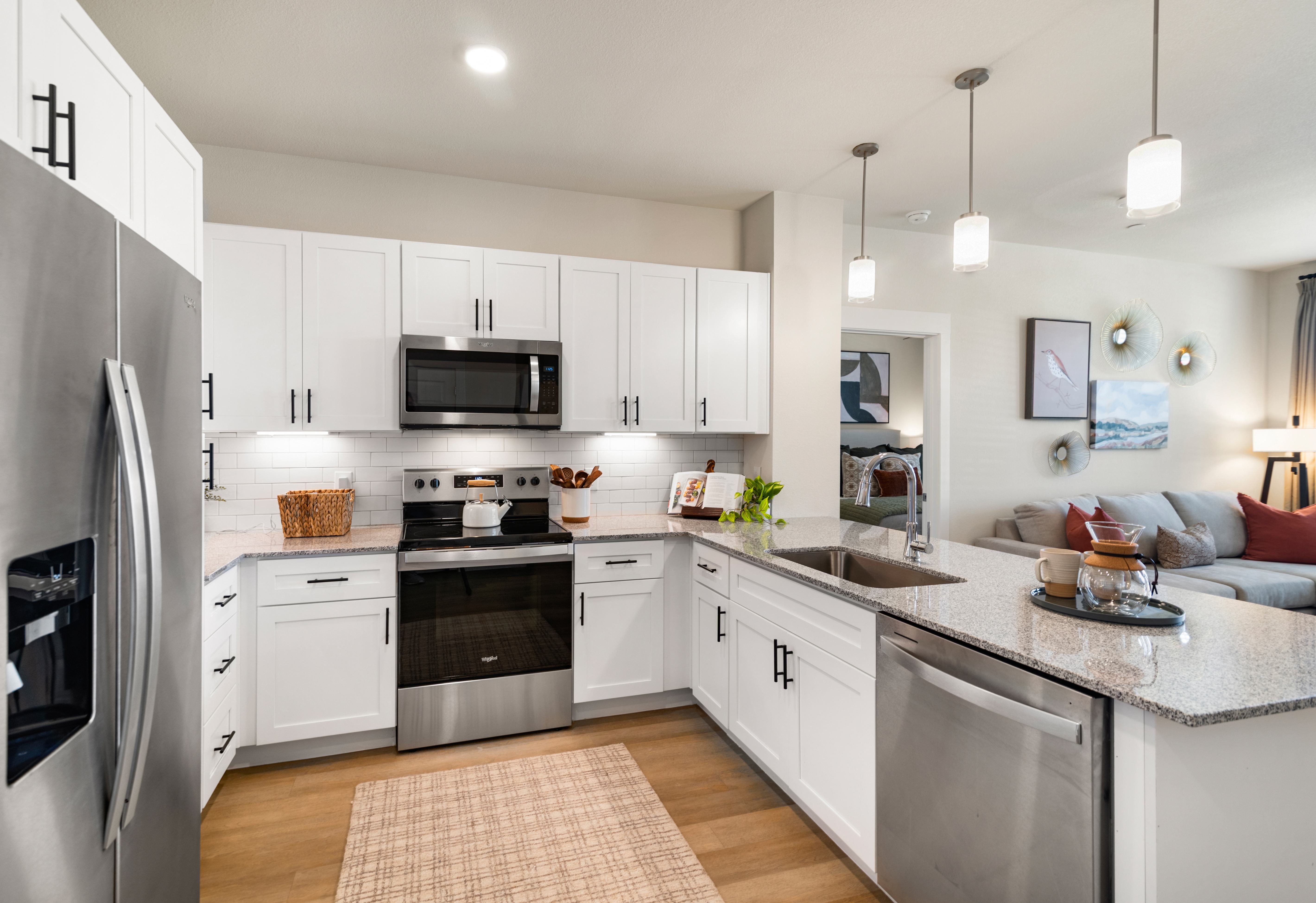 A modern kitchen with white cabinets and stainless steel appliances.