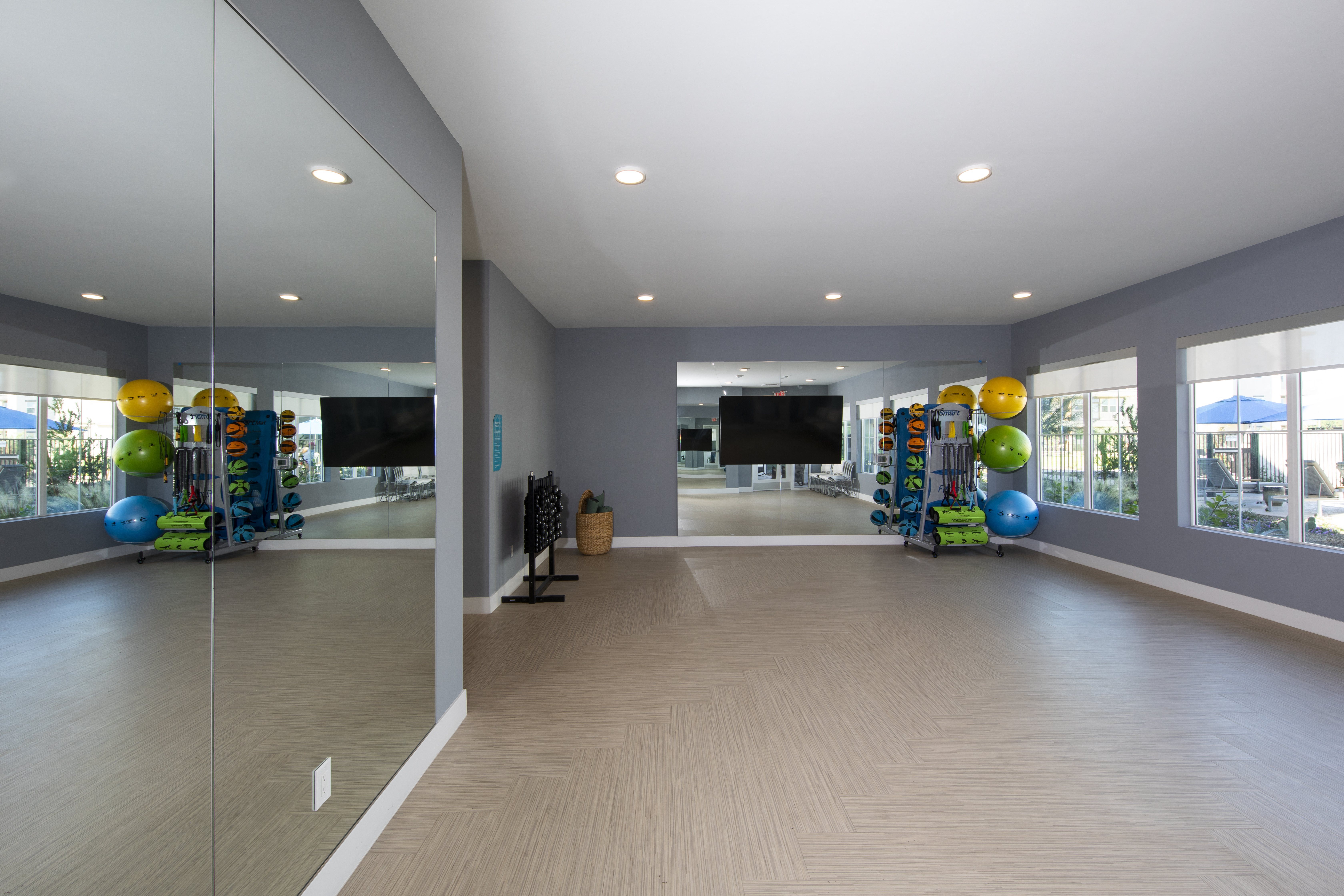 a fitness room with yoga balls and workout equipment at a senior apartment community