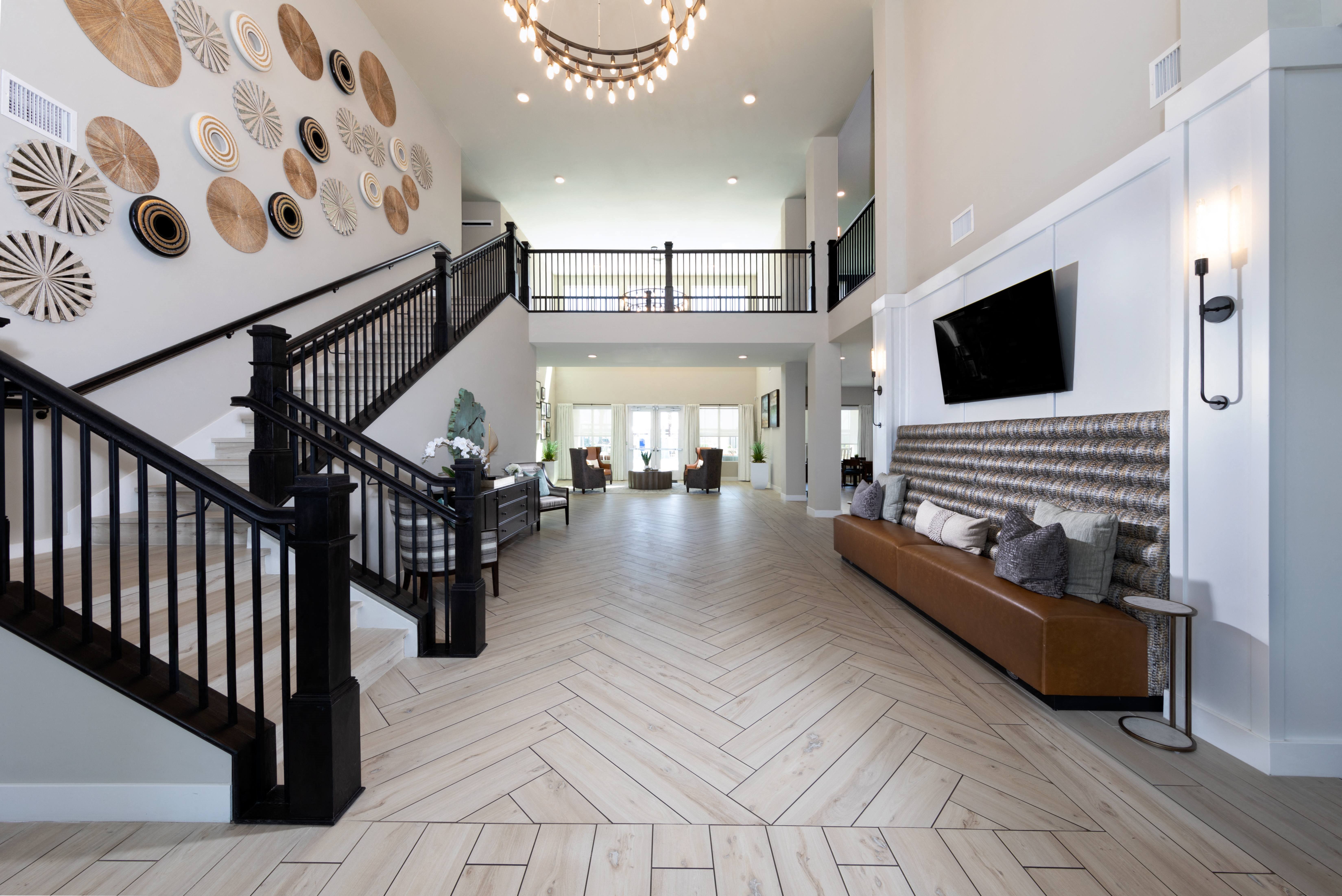 the lobby with a large staircase and seating at a senior apartment community