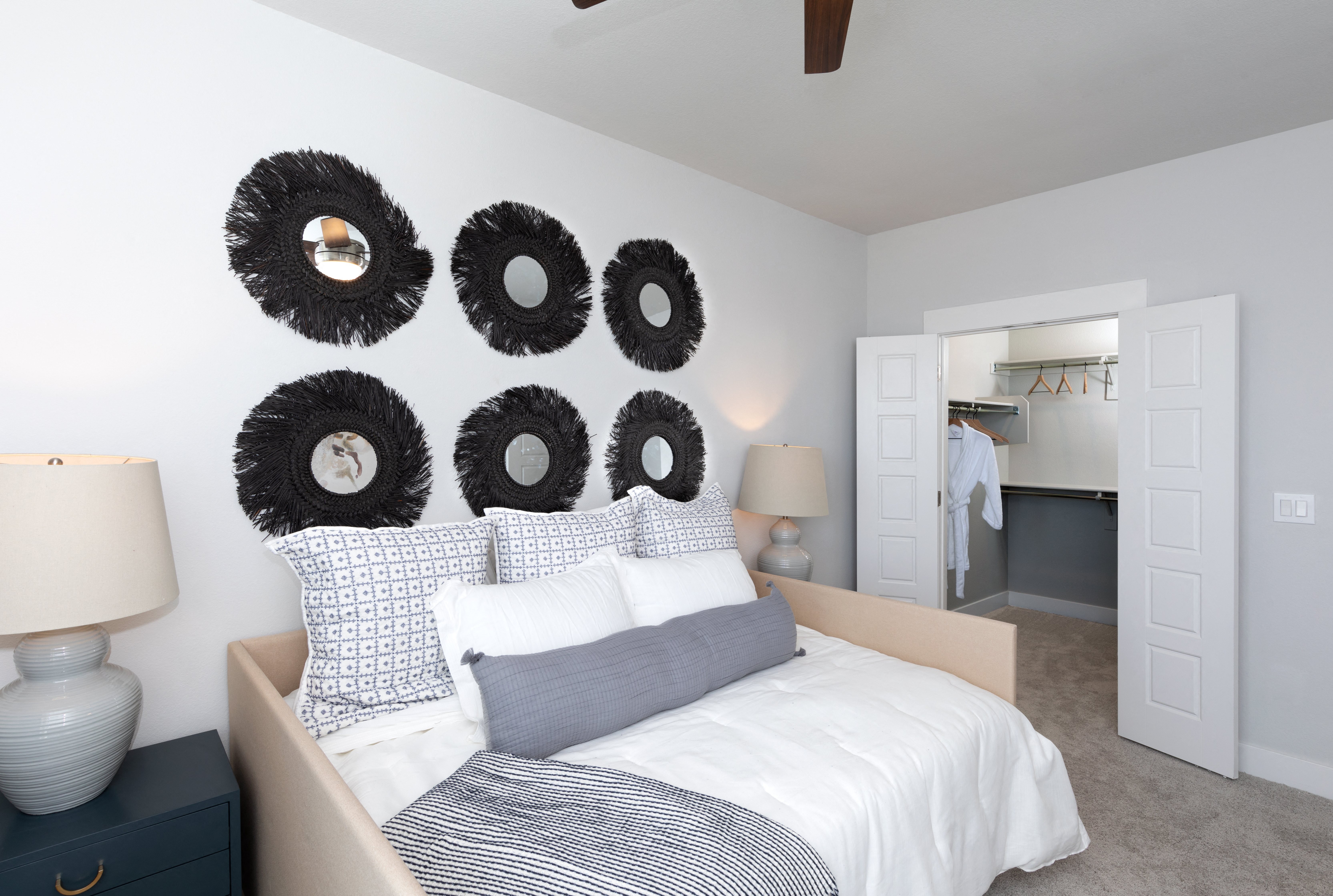 a bedroom with a bed and several mirrors on the wall