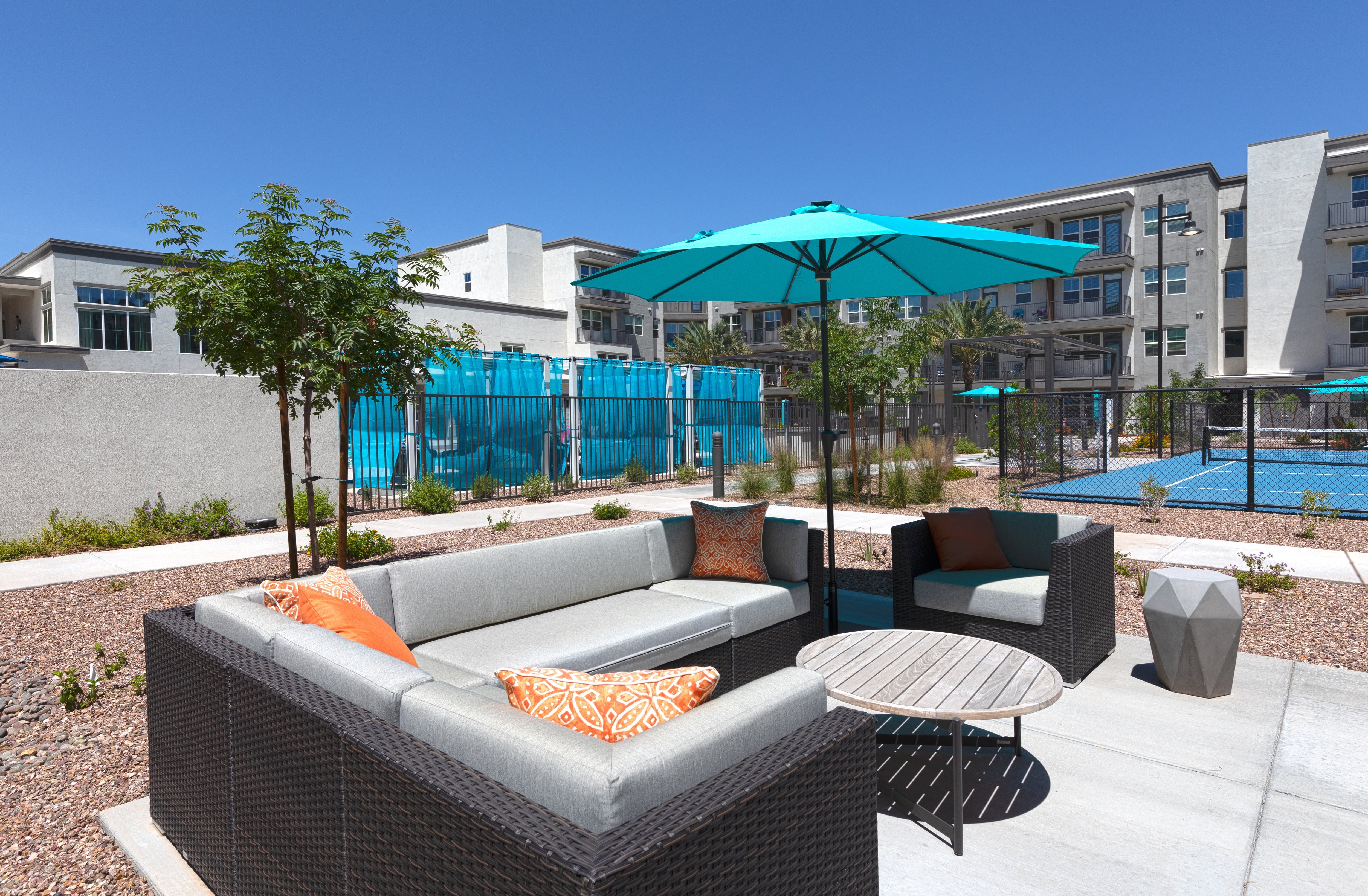 a patio with seating and an umbrella at a senior apartment community
