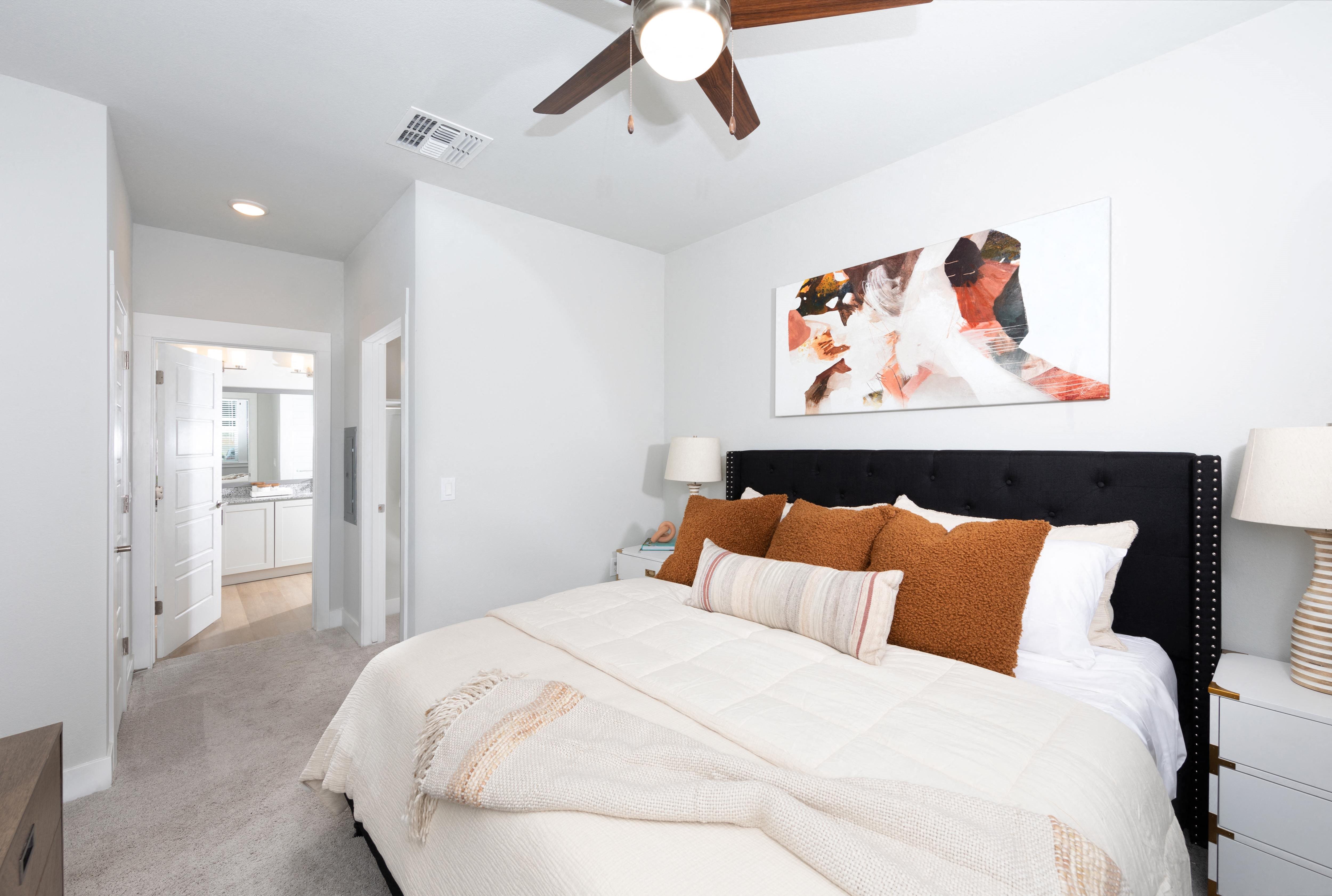a bedroom with a queen-sized bed and ceiling fan at a senior apartment community
