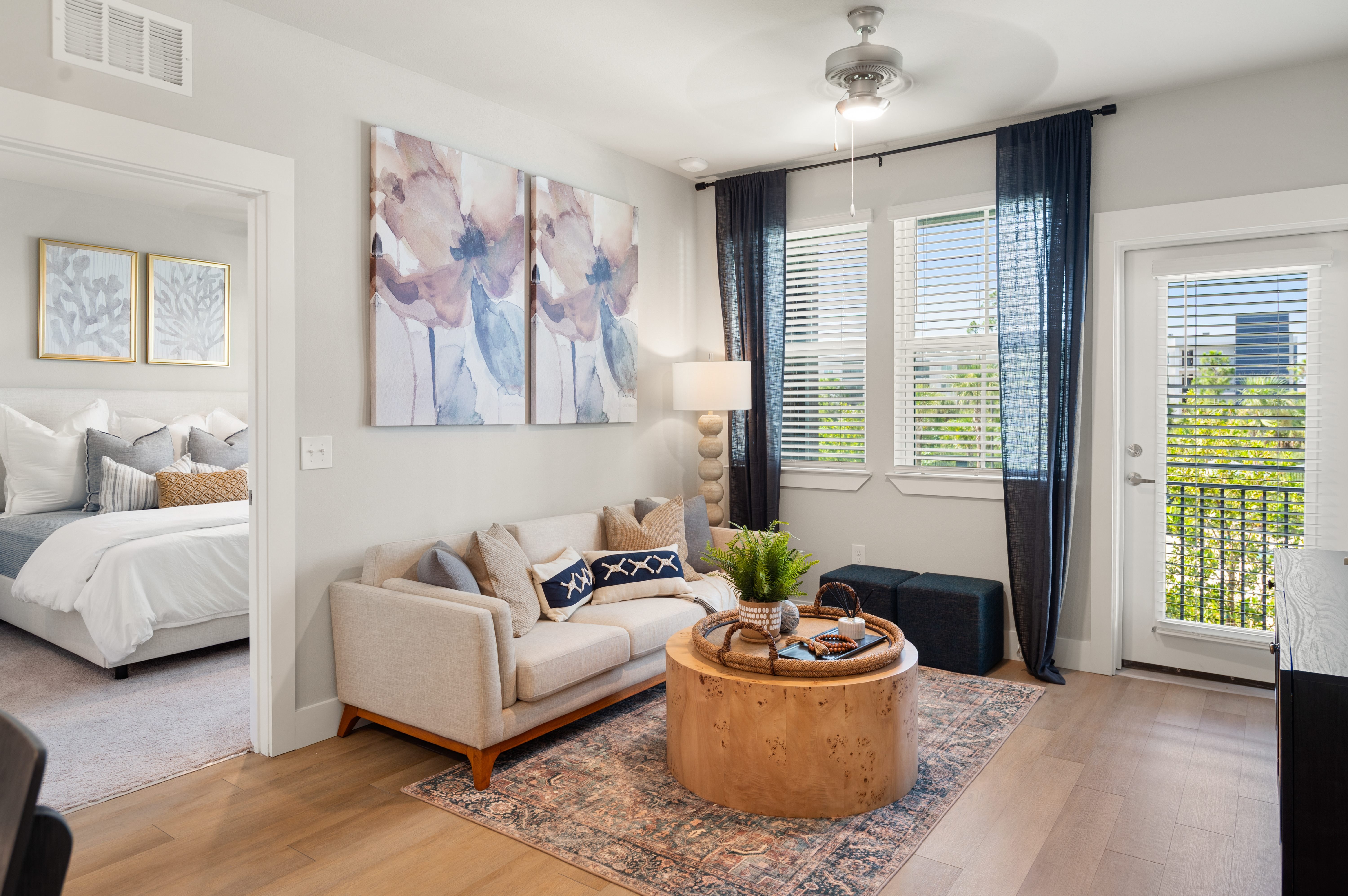 A living room with a white couch and a large painting on the wall.