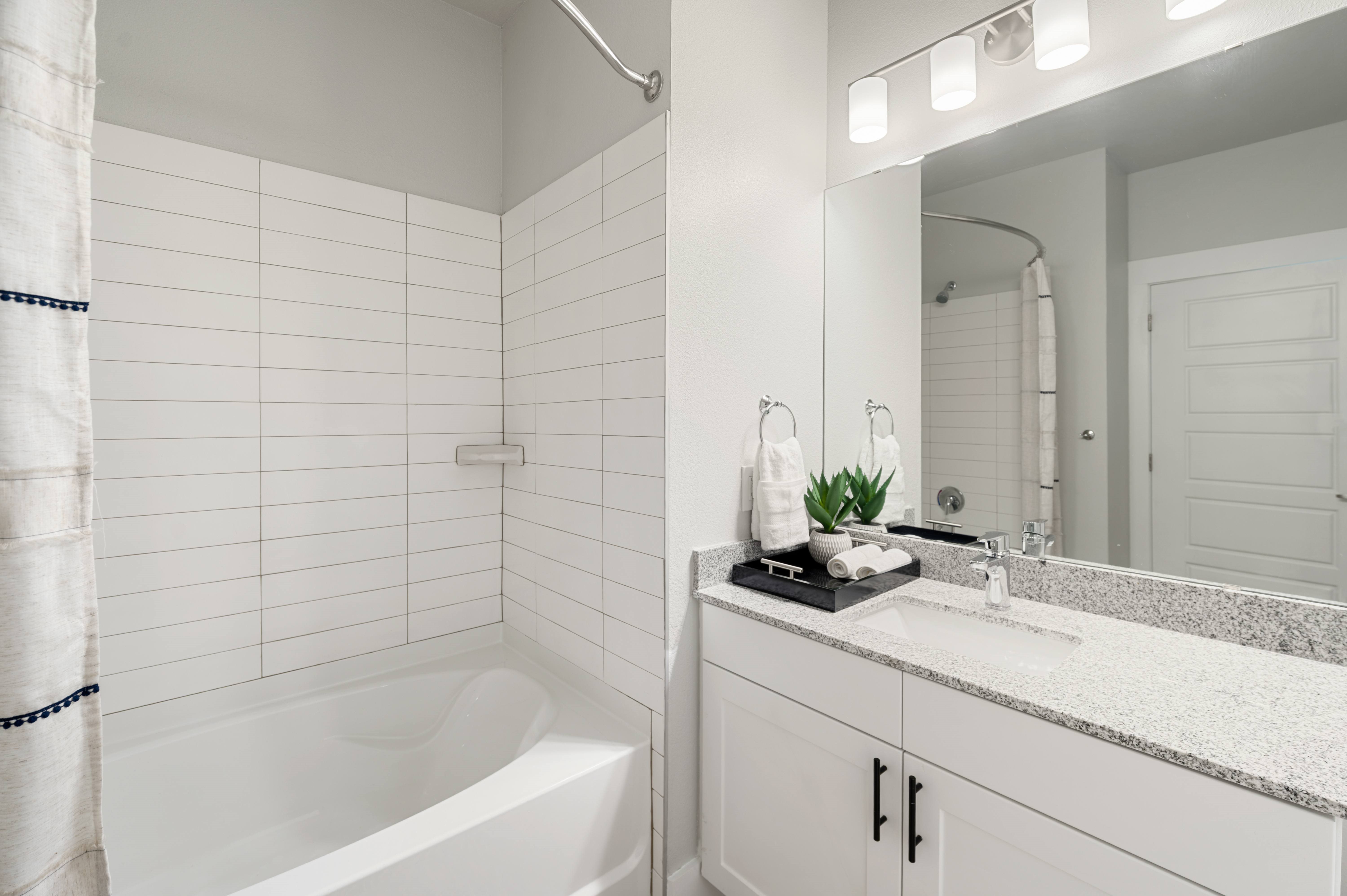 A white bathroom with a white tub and sink.
