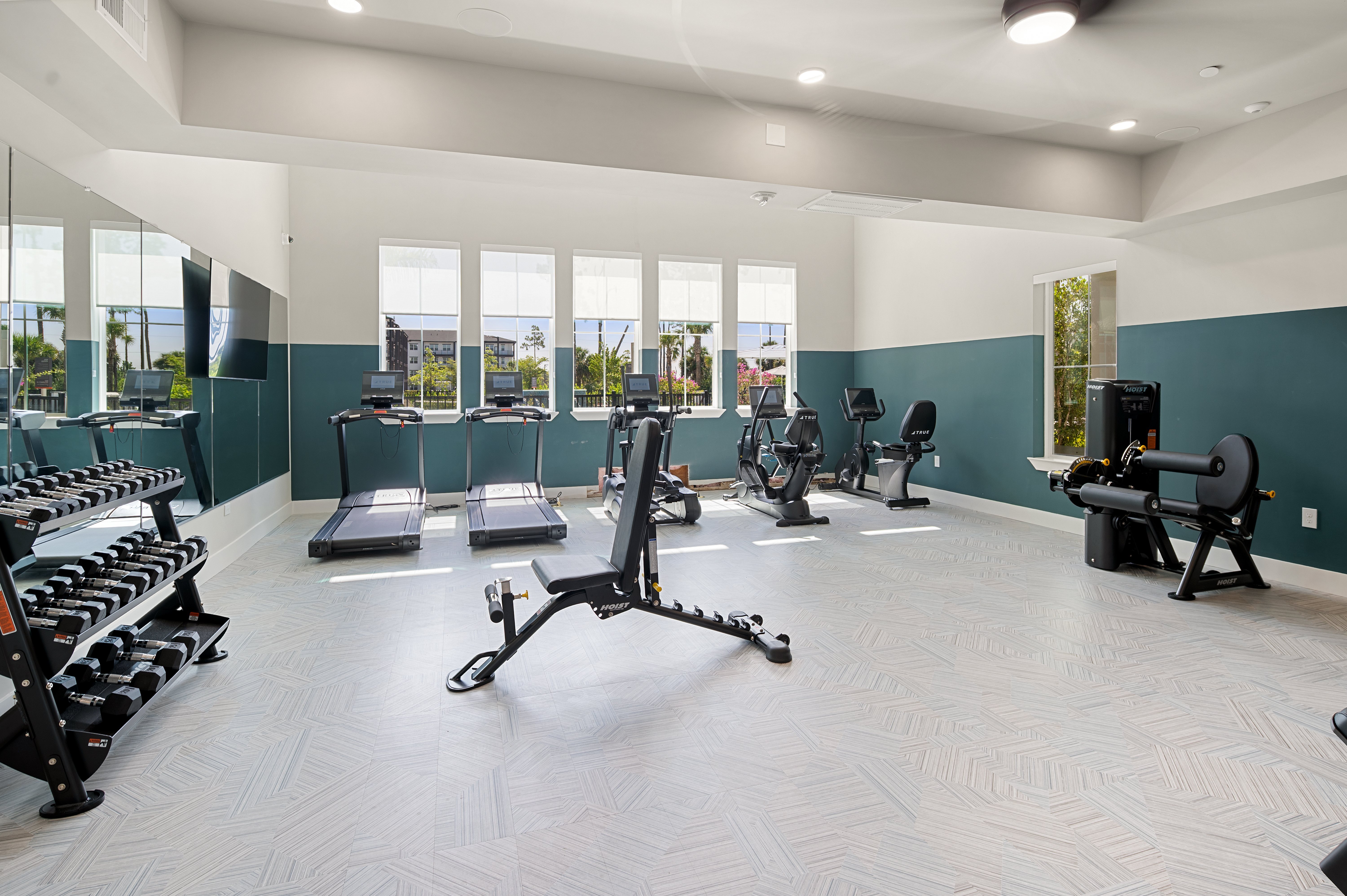 A gym with a variety of equipment including weights and cardio machines.