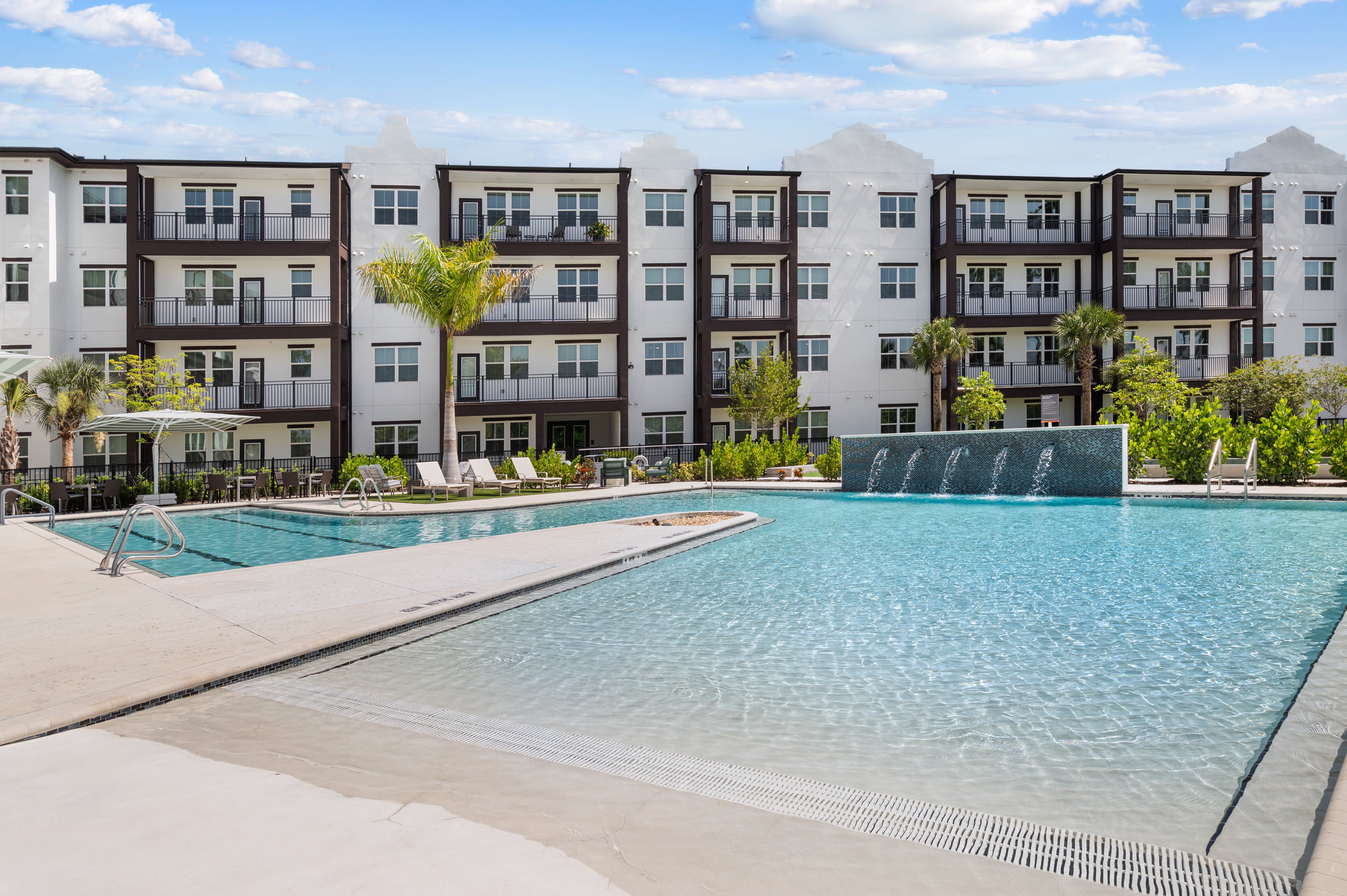 A large swimming pool in front of apartment buildings.