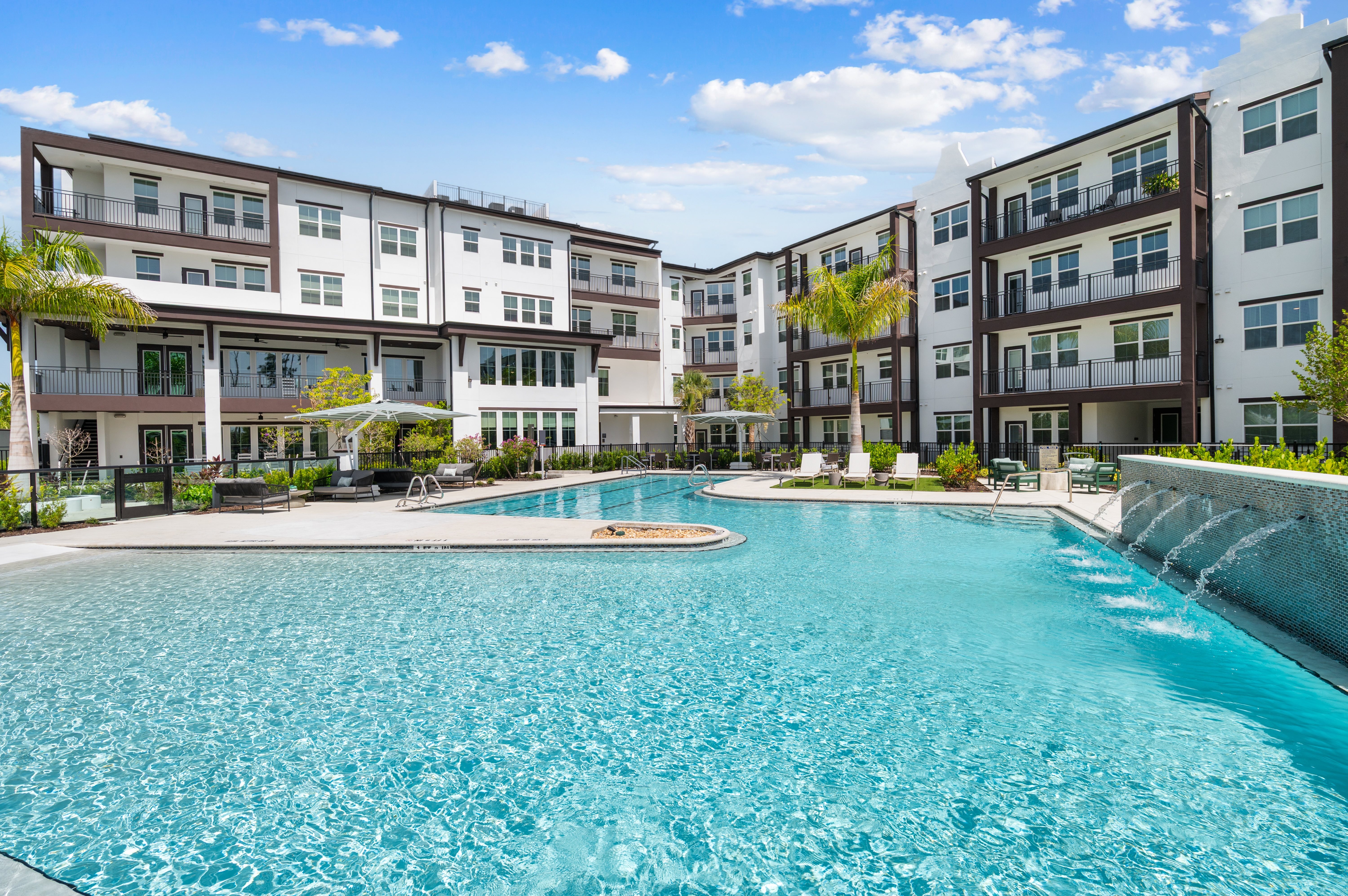 A large swimming pool in front of apartment buildings.
