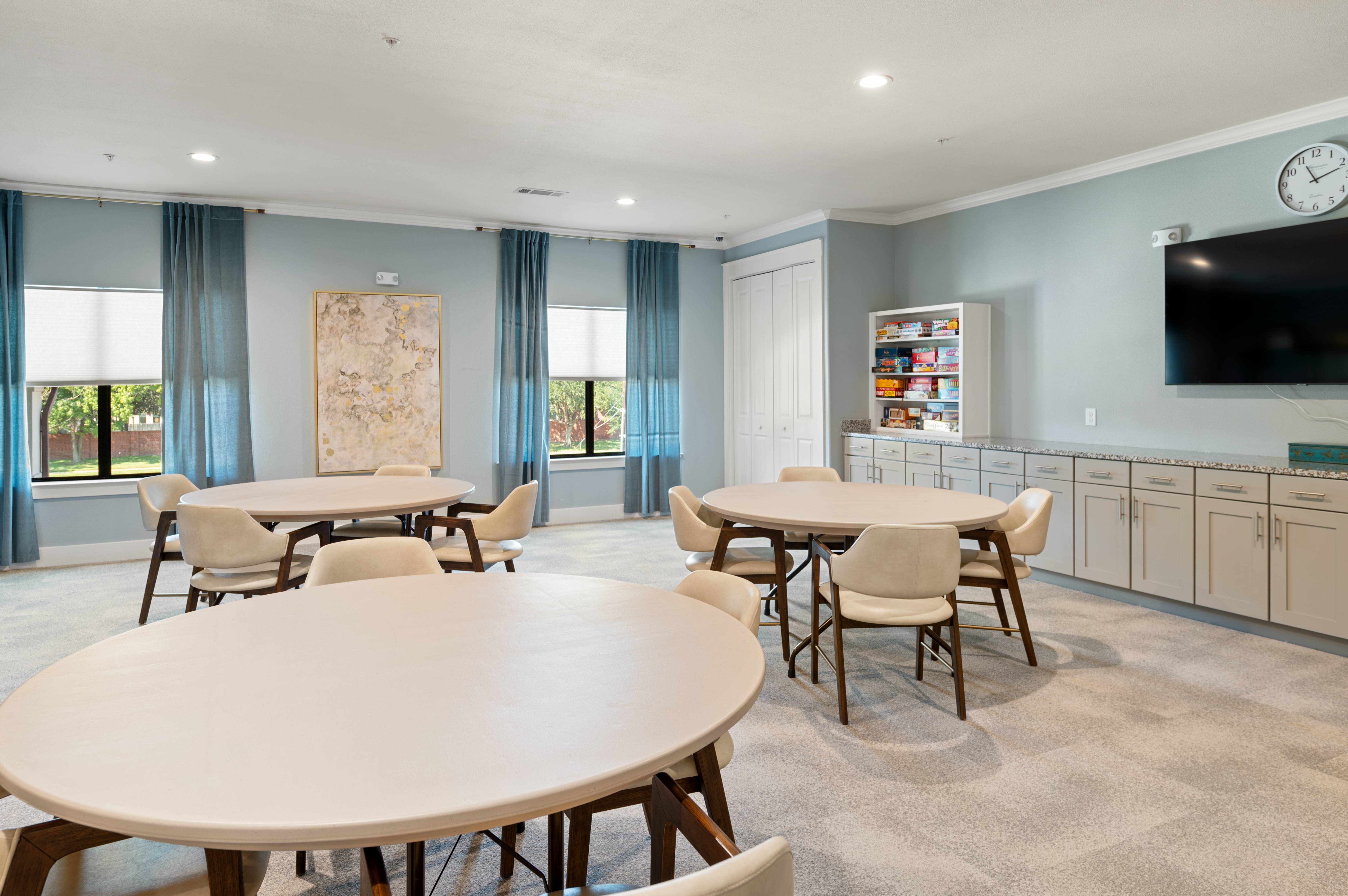 A dining room with a large table and chairs.