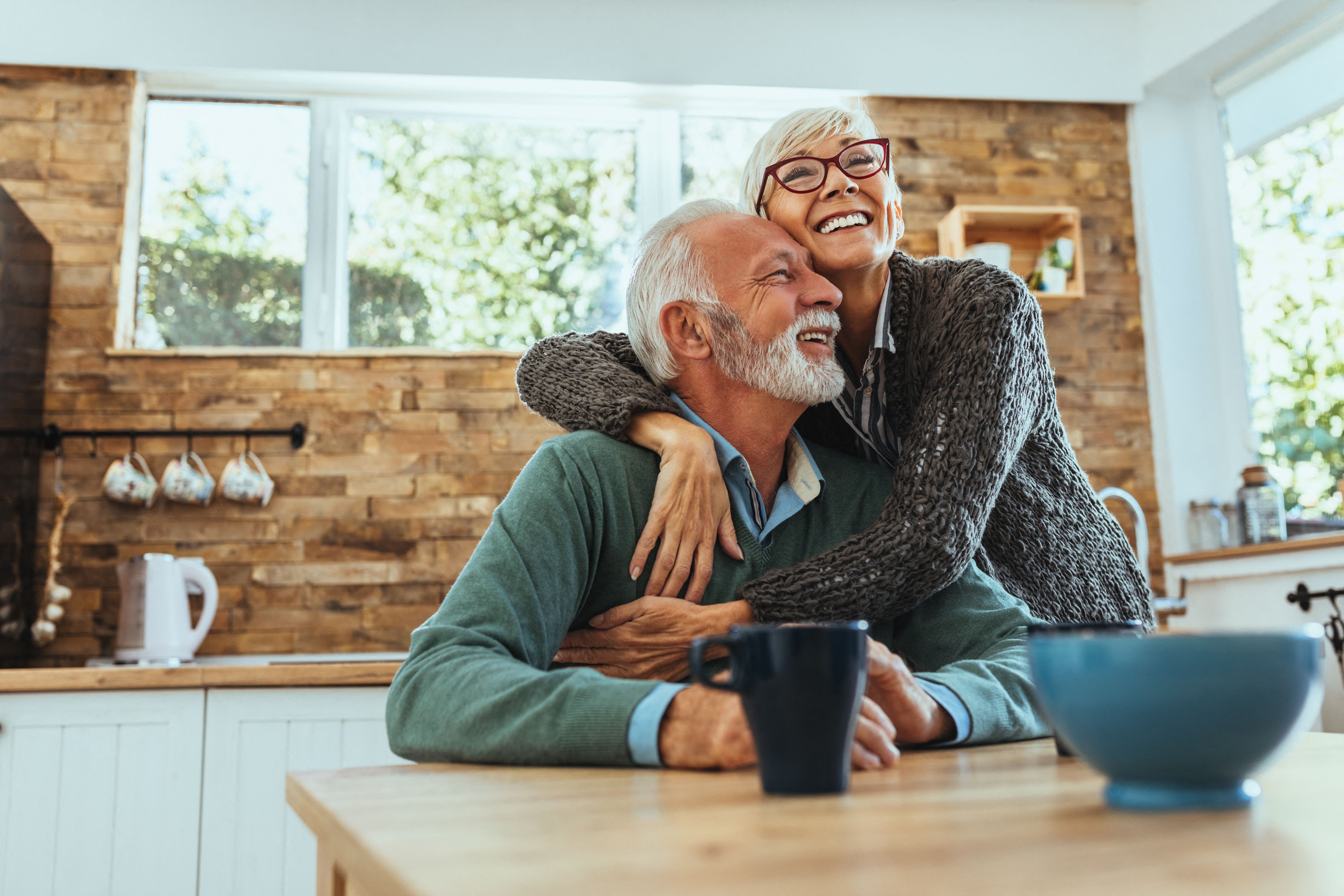 an older man and woman laughing together at a senior apartment community