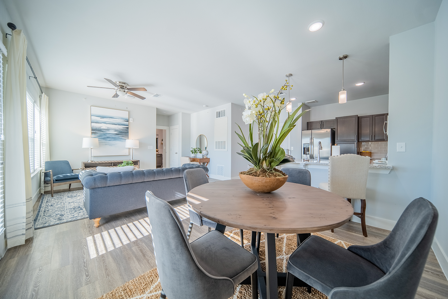 a large living room with a small dining area at a senior apartment community