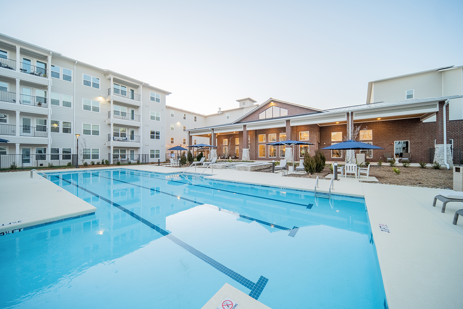 a resort-style pool with lounge areas at a senior apartment community