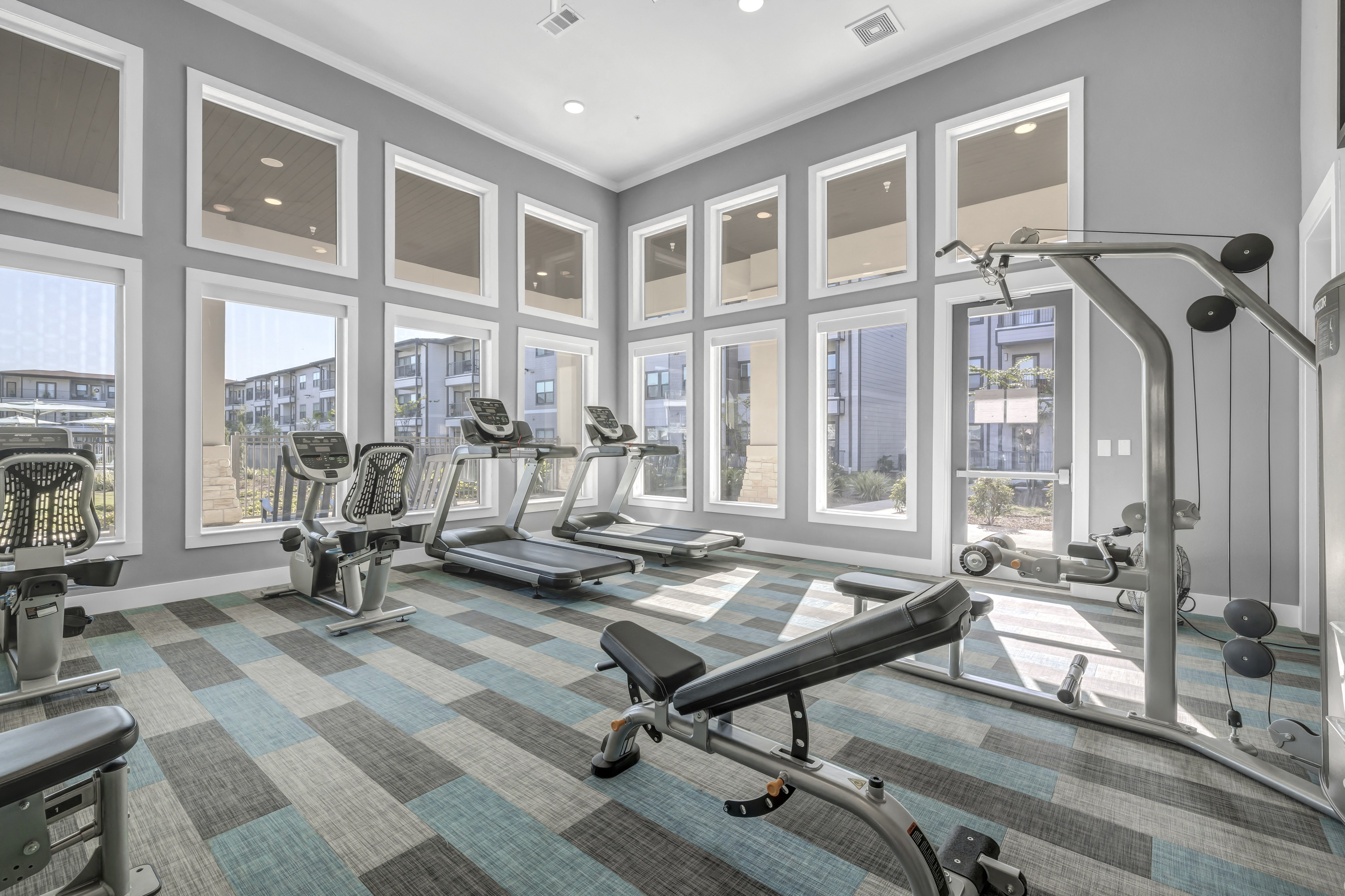 a gym with fitness machines and equipment at a senior apartment community