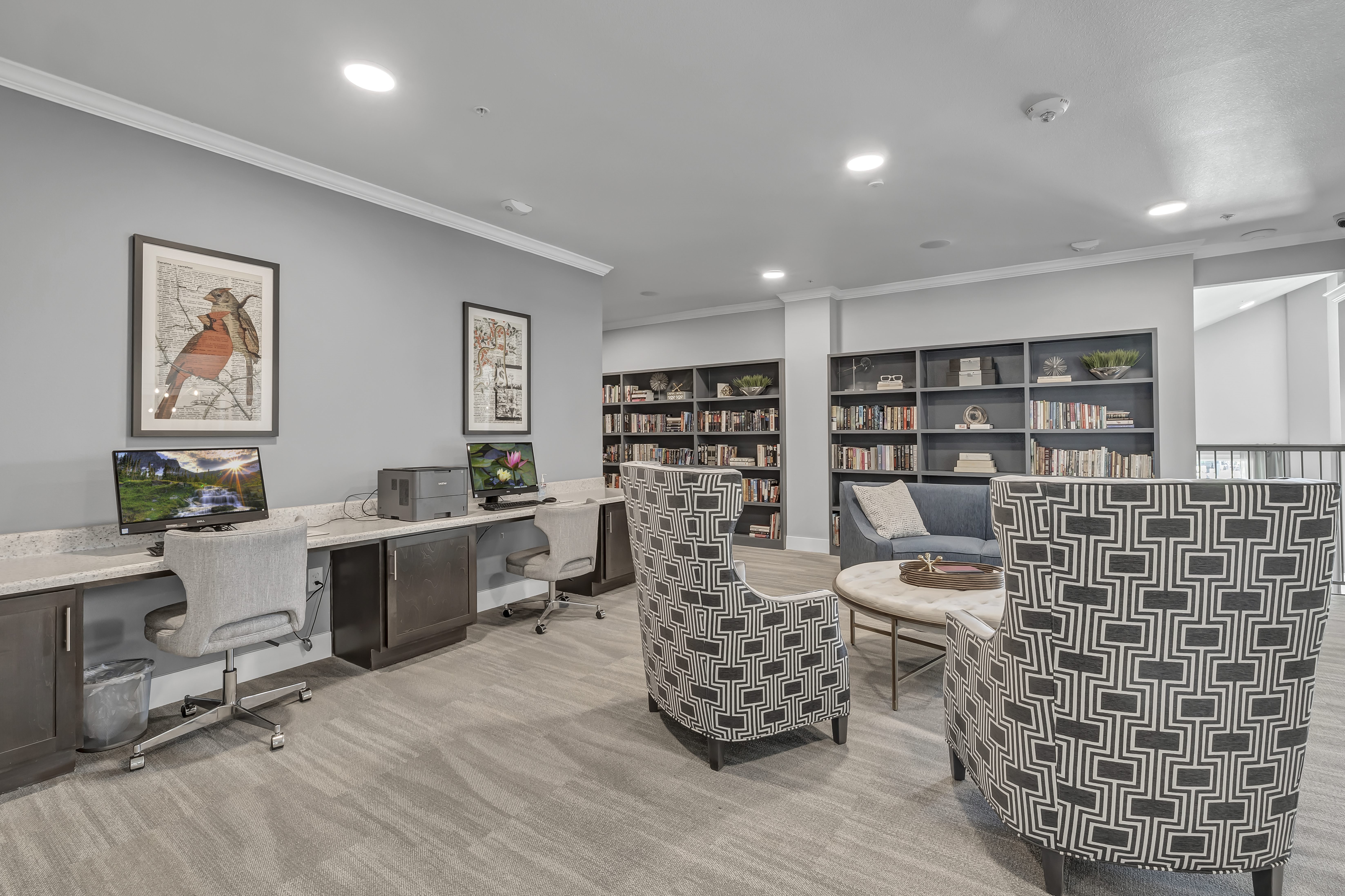 A room with a desk, chairs, and bookshelves.