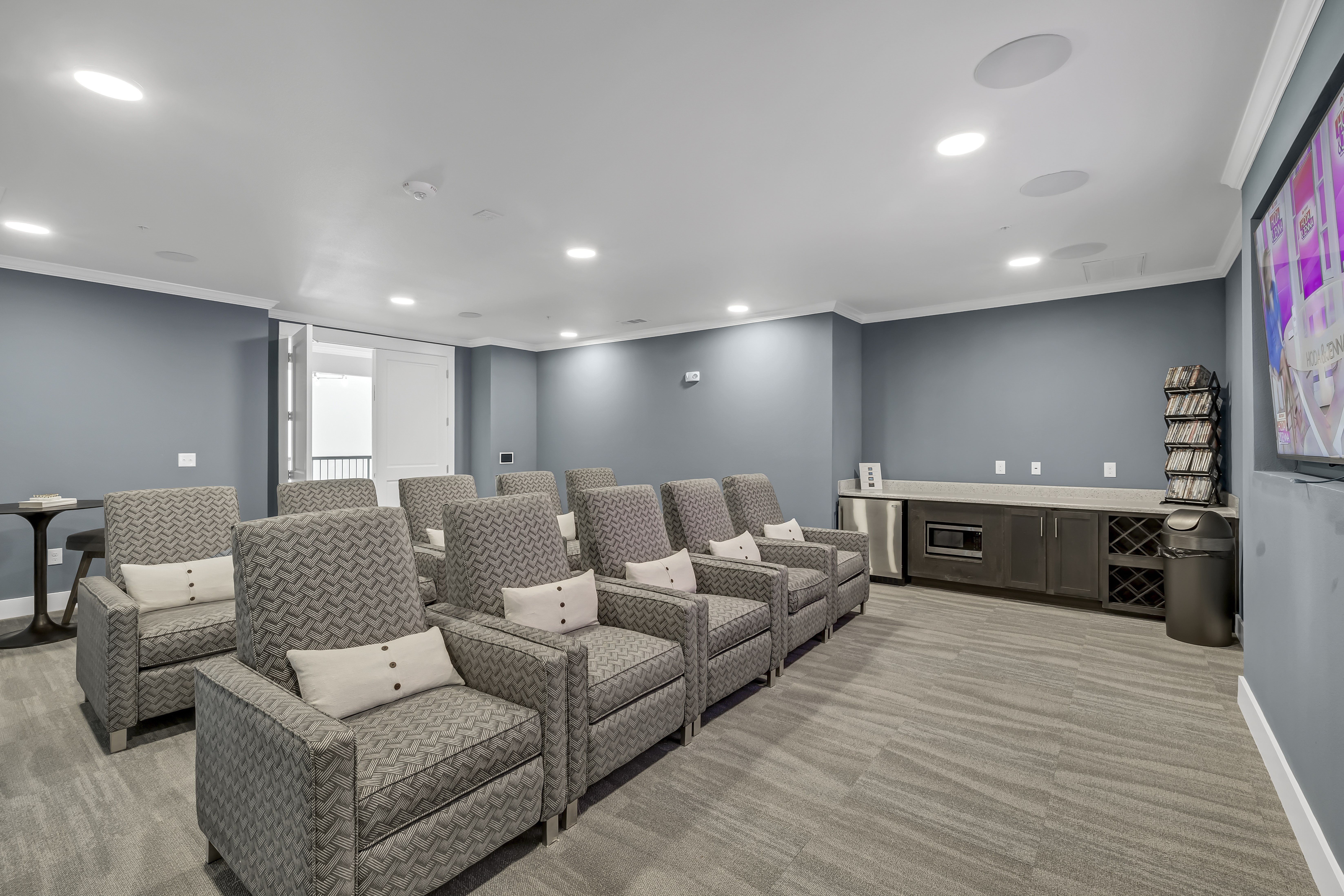 A living room with grey walls and a grey carpet.