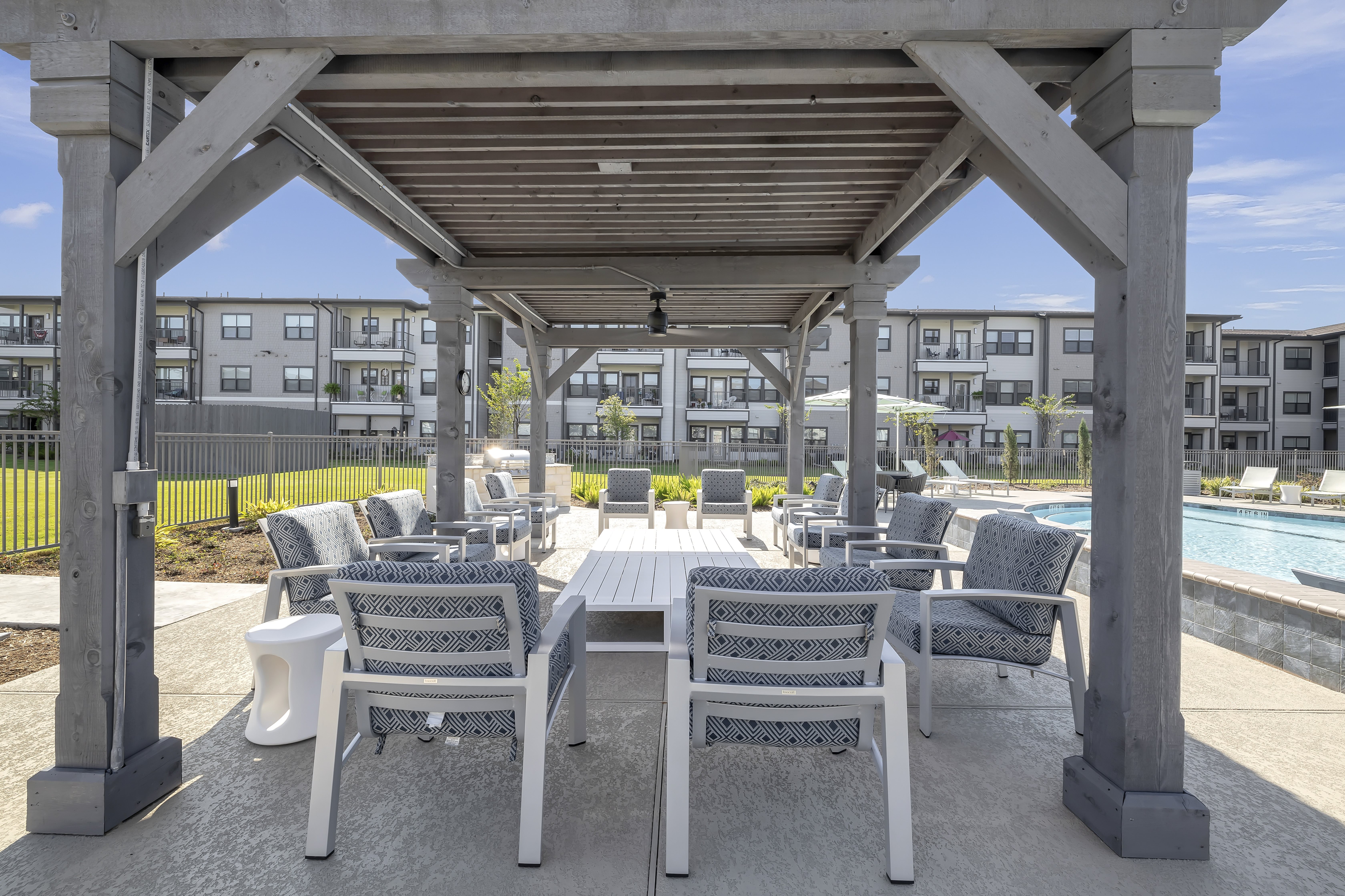 A patio with a table and chairs under a roof.