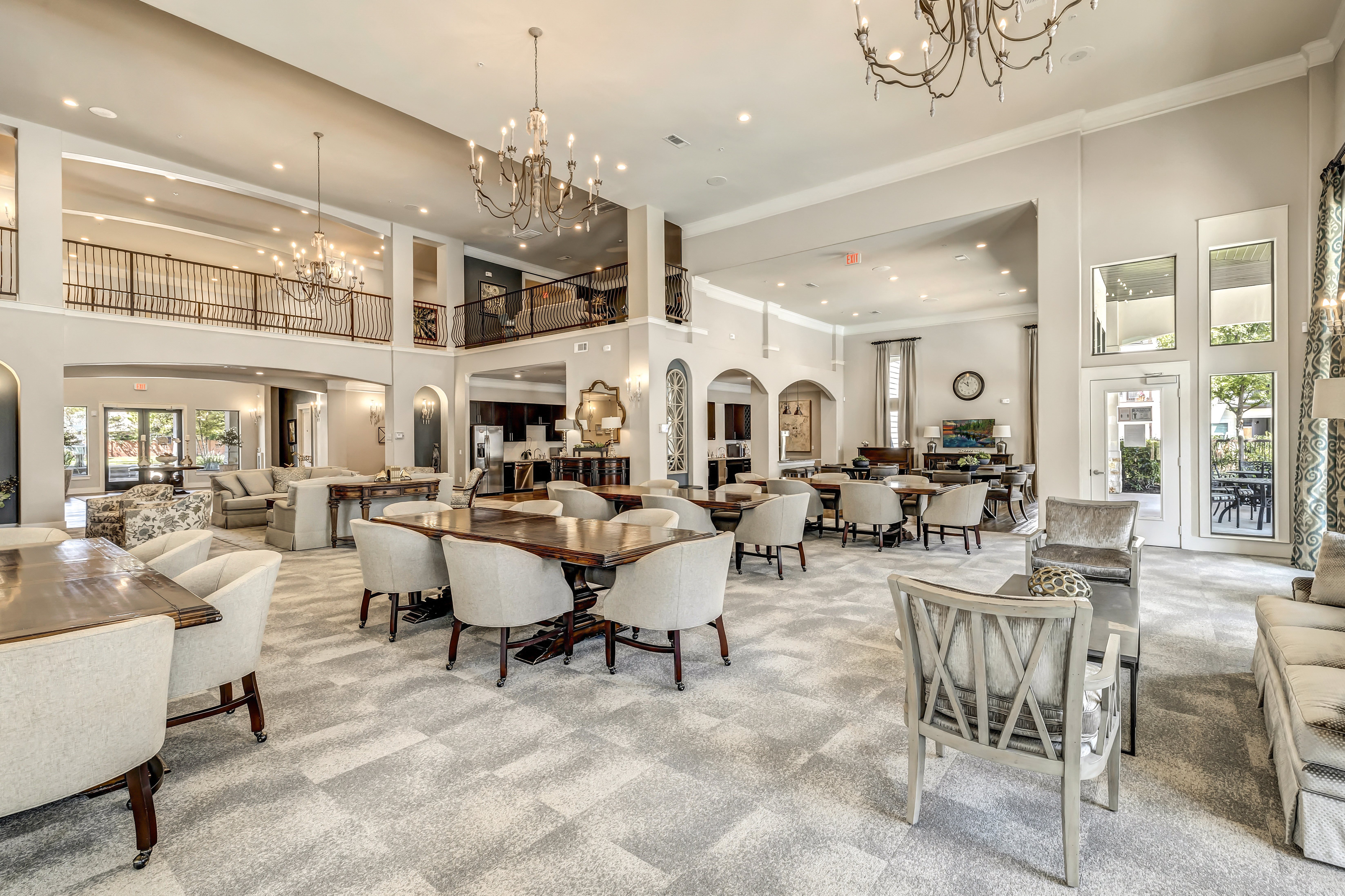 a communal clubhouse dining room with tables and chairs at a senior apartment community