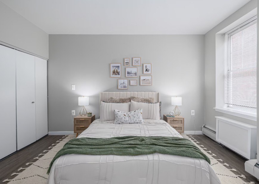 A bedroom with a large bed and a green blanket.