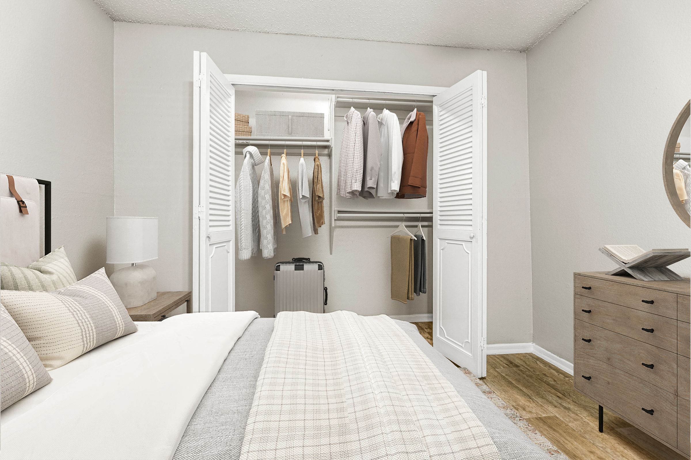 a bedroom with a bed and a closet full of clothes at 5636 Apartment Homes, Dallas, TX  75254