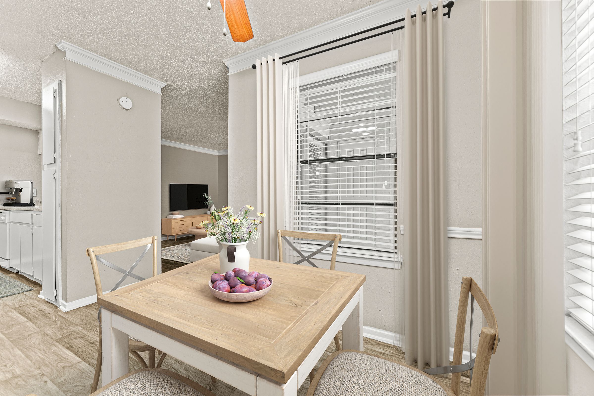 a dining room with a table and chairs and a large window at 5636 Apartment Homes, Dallas  75254
