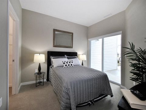 a bedroom with a bed and a door to a patio at The George, Ann Arbor, MI