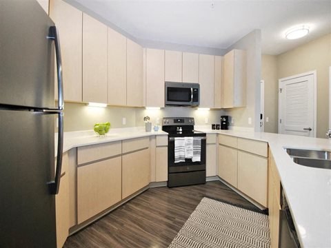a kitchen with a stove top oven next to a refrigerator at The George, Michigan, 48104