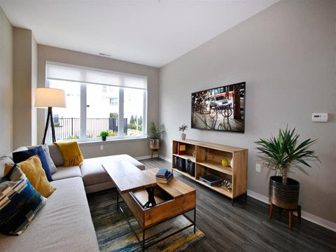 a living room with a couch and a coffee table at The George, Ann Arbor, MI 48104