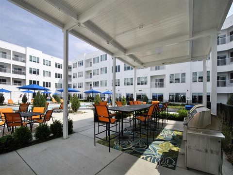 a patio with a table and chairs and a grill at The George, Ann Arbor, MI 48104