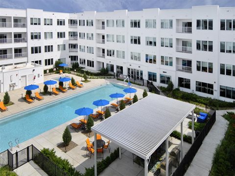a large white building with a swimming pool in front of it at The George, Ann Arbor, MI