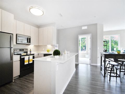 a kitchen with a large white island next to a doorway at The George, Ann Arbor