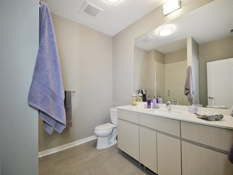 a bathroom with a toilet sink and mirror at The George, Ann Arbor, 48104