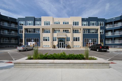 a large apartment building with a parking lot in front of it at The George, Ann Arbor