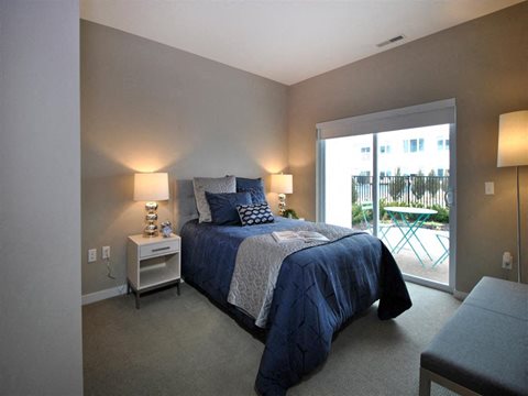 a bedroom with a bed and a sliding glass door at The George, Michigan, 48104