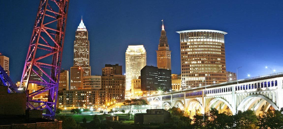 A city skyline at night with a bridge and a crane.