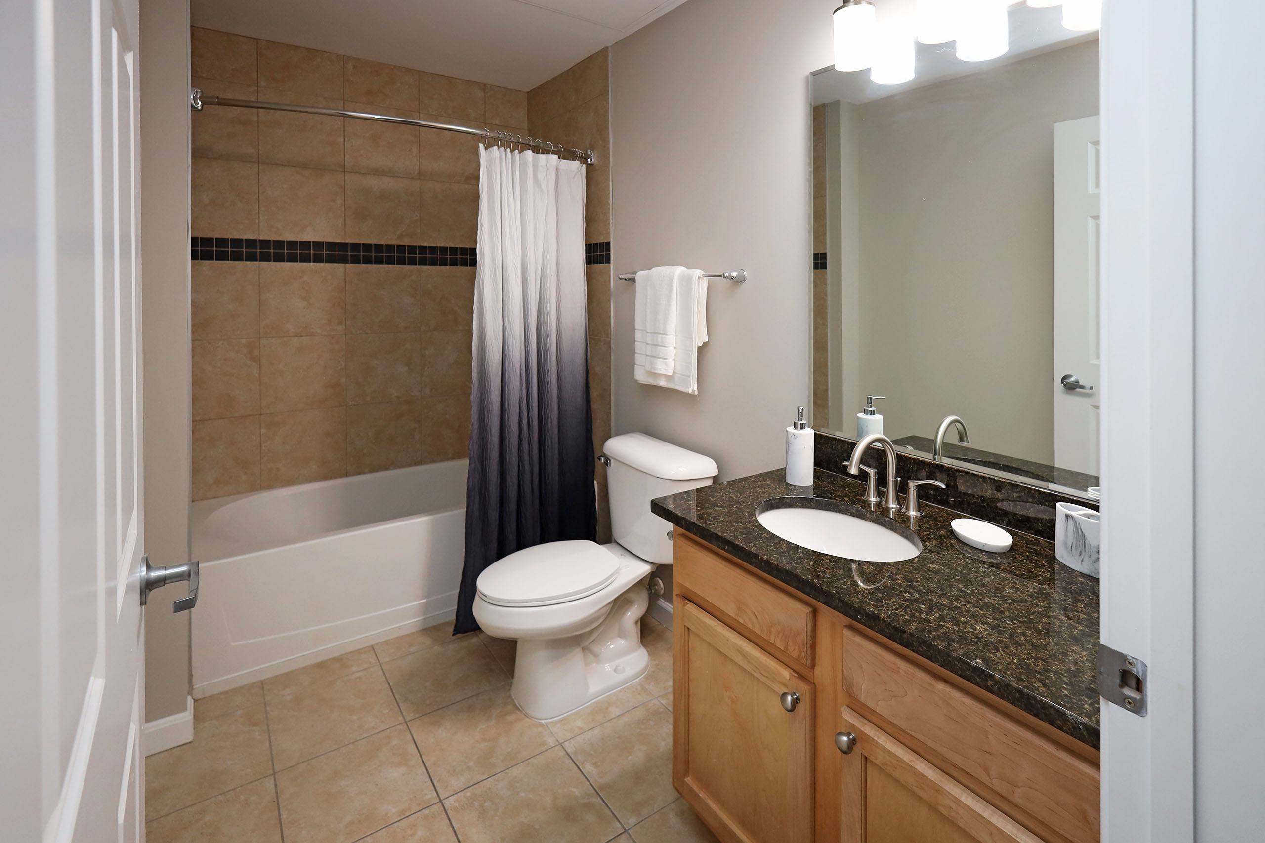 A bathroom with a toilet, sink, and shower.