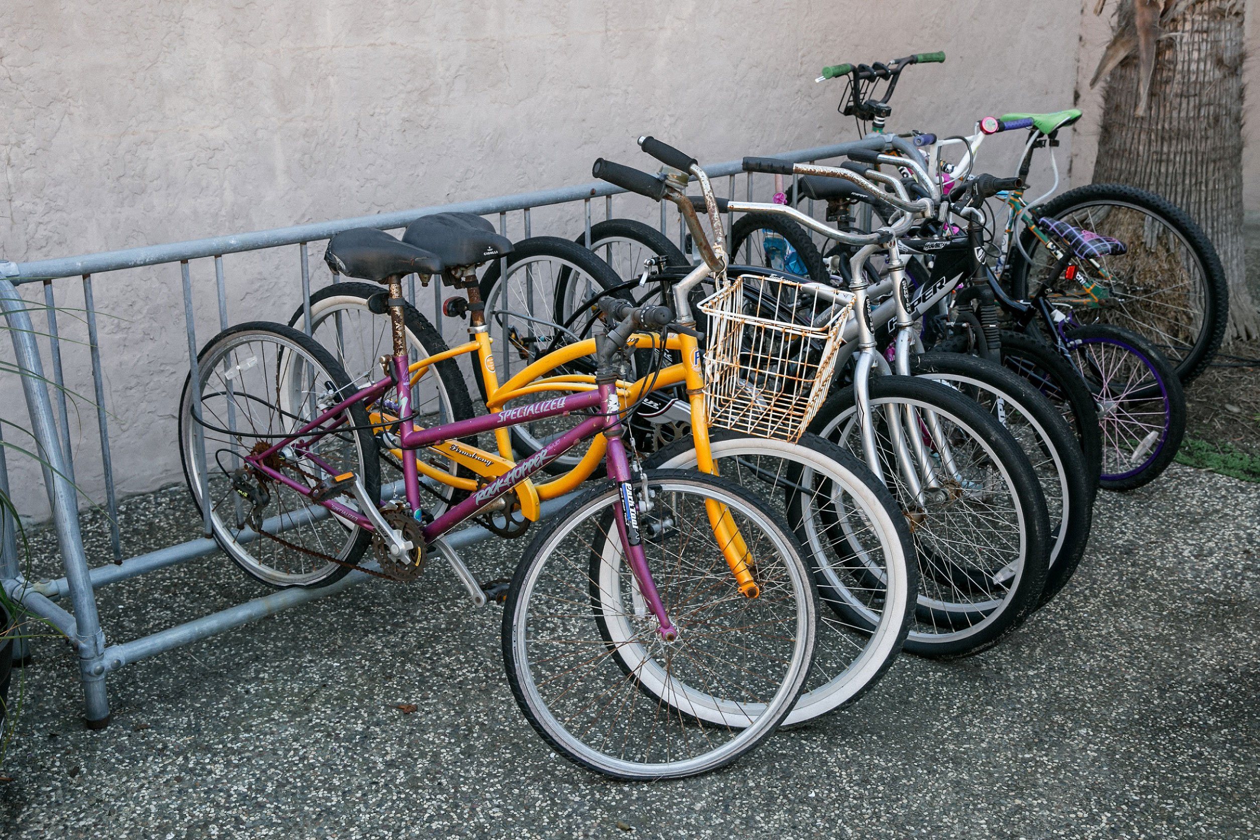 A group of bicycles are parked next to a metal fence.