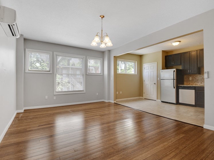 Living room with hardwood floors and kitchen with stainless steel appliances