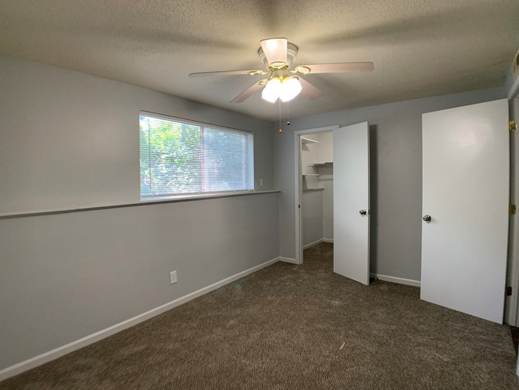 large carpeted room with closet and ceiling fan