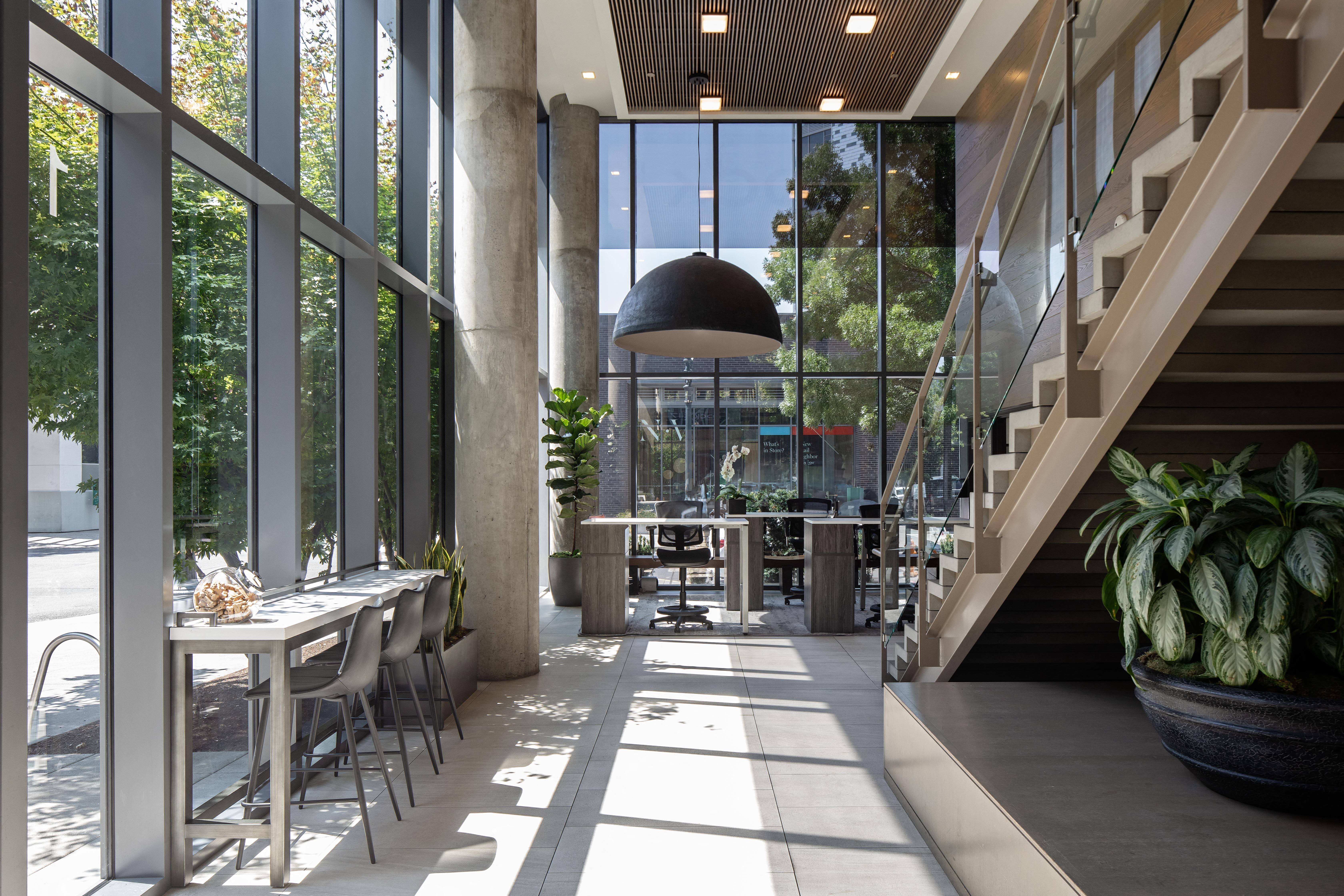 a dining room with large windows and a staircase